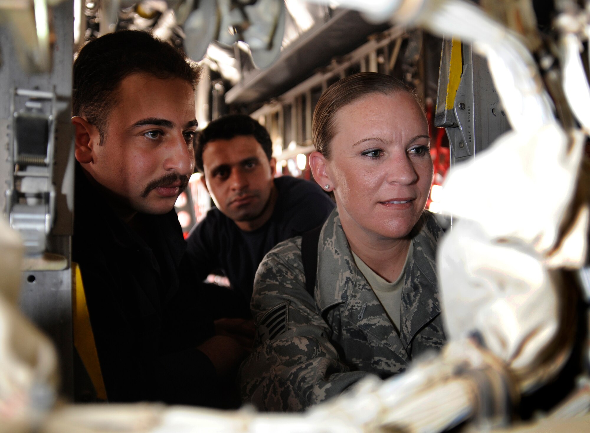 NEW AL MUTHANNA AIR BASE, Iraq -- Tech. Sgt. Julie Litz, electrical and environmental specialist assigned to the 321st Air Expeditionary Advisor Squadron here, explains the different codes that could fault a C-130's generator control unit Sept. 5, 2009. Sergeant Litz works with 25 Iraqi airmen, teaching them different skills from alternating and direct current pressure to air conditioning. Sergeant Litz's goal is to get them trained to a higher level during her deployment. Sergeant Litz is deployed from Travis Air Force Base, Calif., and is a native of Escalon, Calif. (U.S. Air Force photo/Tech. Sgt. Johnny L. Saldivar)