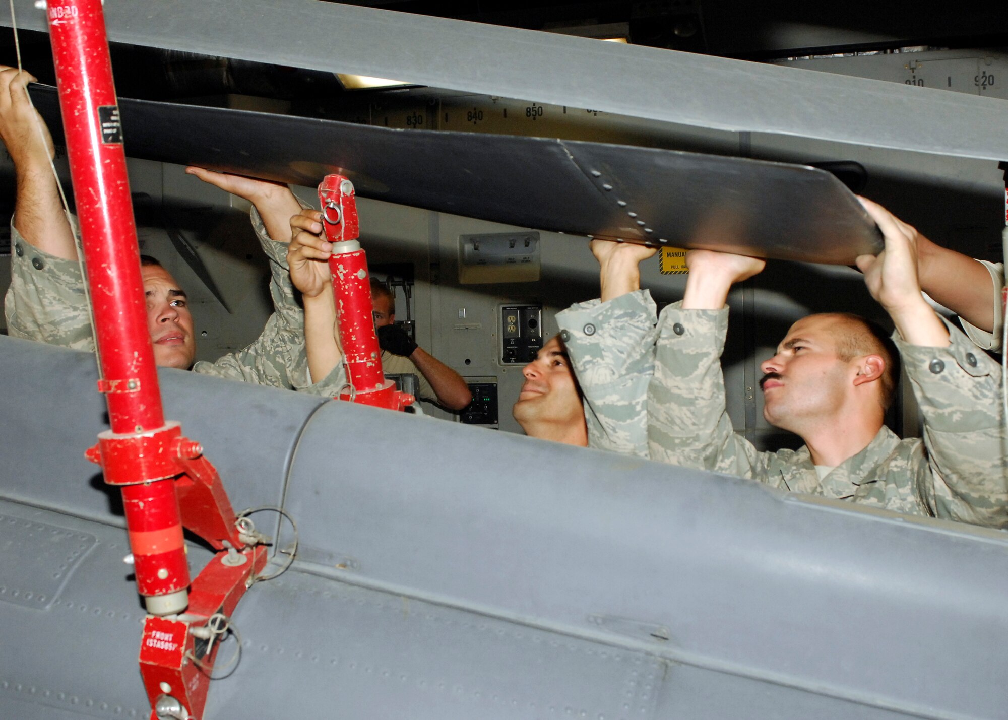 BAGRAM AIRFIELD, Afghanistan -- Senior Airman Josh Berge (left), Staff Sgt. Elias Carlon (middle) and Senior Airman Anthony Boone (right) work together to ensure the HH-60G Pave Hawk doesn't sustain any damage by securing the rotors here, Sept. 9, 2009.  All three of the Airmen are with the 455th Expeditionary Aircraft Maintenance Squadron.  The Pave Hawk was loaded onto a C-17 Globemaster III for its return to home station.  Airman Berge hails from Byron, Minn., Sergeant Carlon hails from Vista, Calif.,  and Airman Boone is a native of Newport News, Va. All three are deployed from Royal Air Force, Lakenheath, England.  (U.S. Air Force photo/Senior Airman Felicia Juenke)