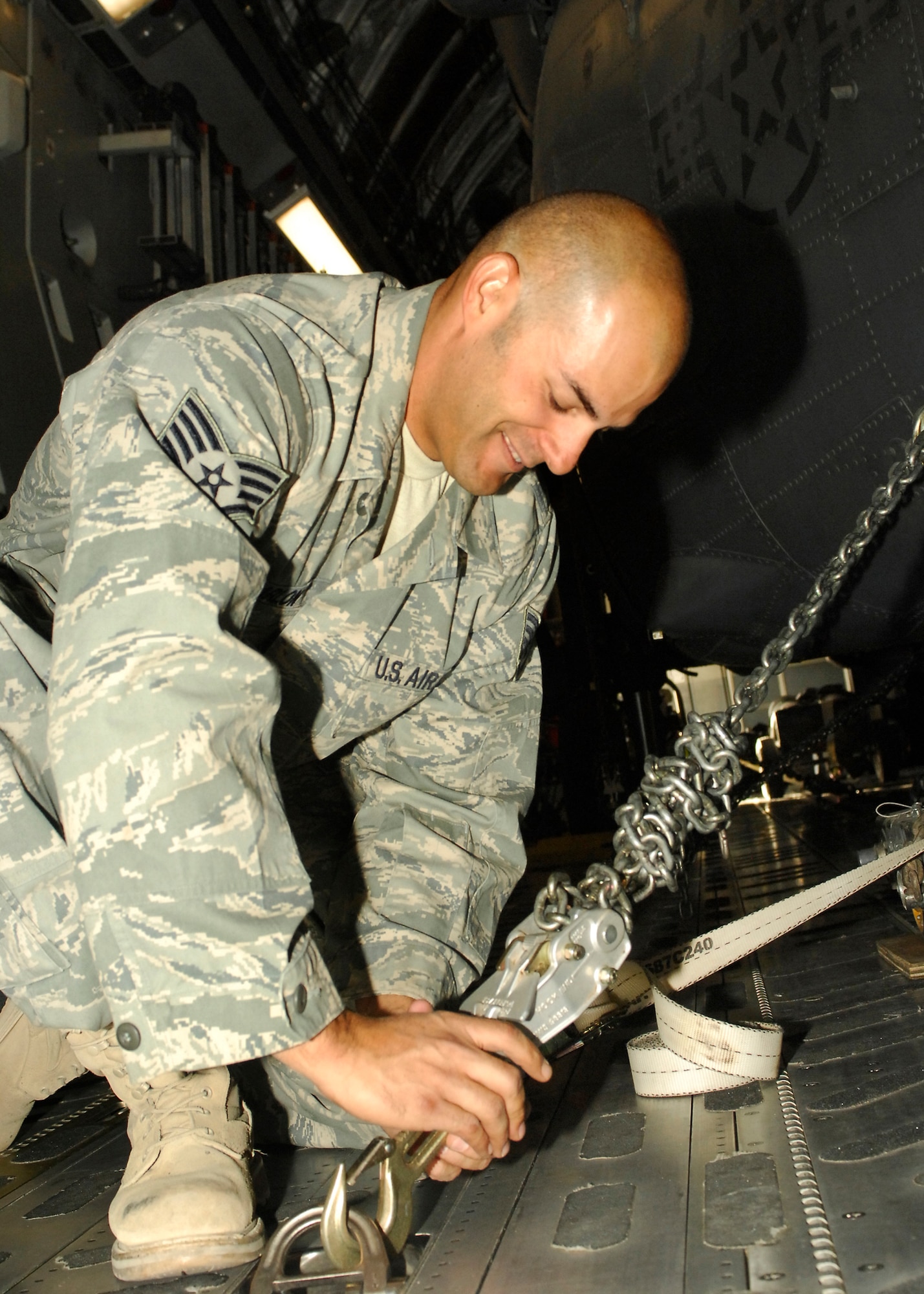 BAGRAM AIRFIELD, Afghanistan -- Staff Sgt. Elias Carlon, an Electronic Warfare Technician with the 455th Expeditionary Aircraft Maintenance Squadron, uses heavy duty harnesses to ensure the HH-60G Pave Hawk doesn't get damaged on the C-17 Globemaster III here, Sept. 9, 2009.  Sergeant Carlon is deployed from RAF Lakenheath, England, and hails from Vista, Calif.  (U.S. Air Force photo/Senior Airman Felicia Juenke)