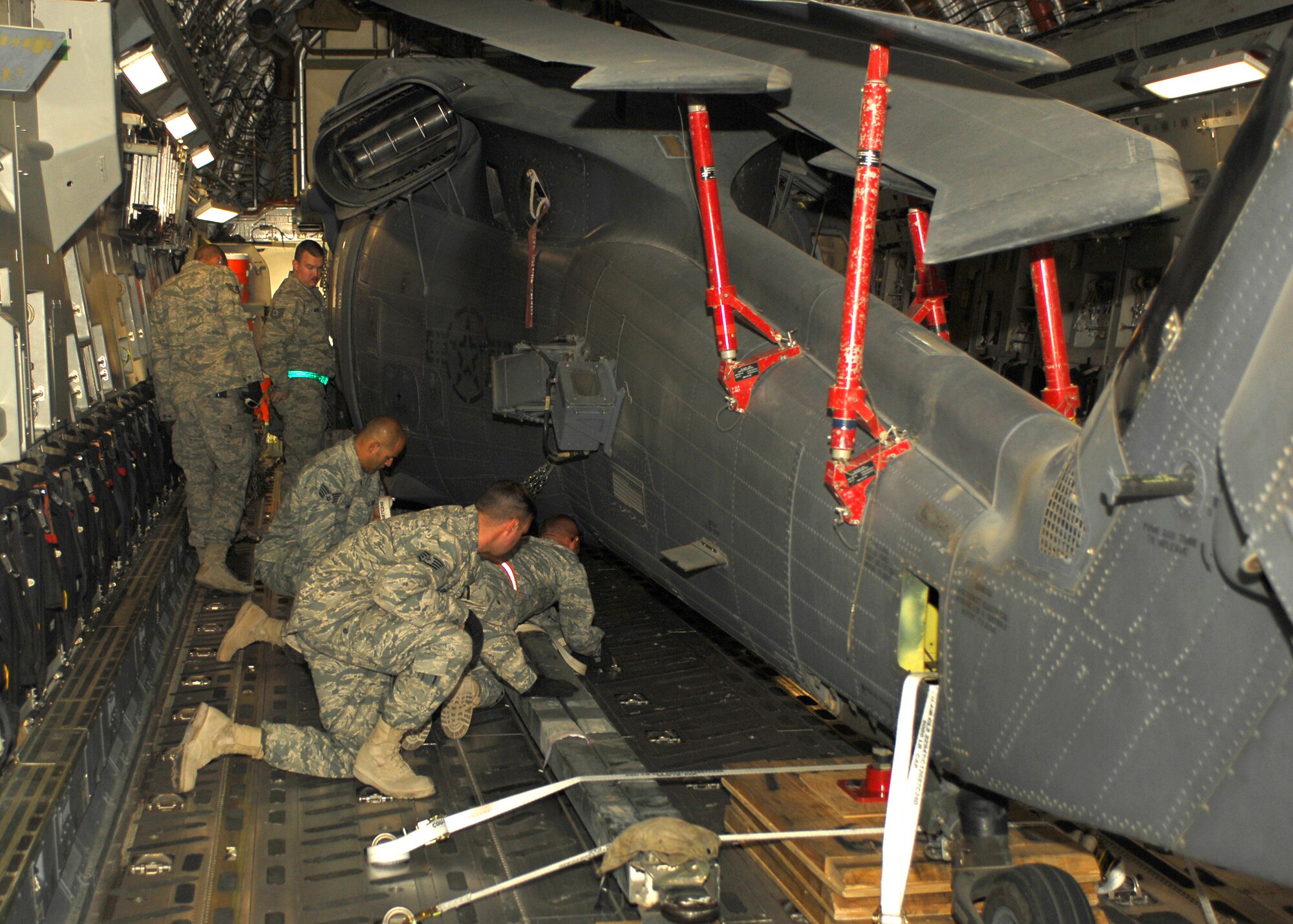 BAGRAM AIRFIELD, Afghanistan -- Members of the 455th Expeditionary Aircraft Maintenance Squadron ensure an HH-60G Pave Hawk is secure aboard a C-17 Globemaster III here, Sept. 9, 2009. The Pave Hawk is on its way back to home station after a tour of duty at BAF. The Pave Hawk's primary wartime mission is combat search and rescue. The Globemaster III is a versatile transport aircraft and its cargo compartment is designed to carry a wide range of cargo to include large vehicles, tanks and helicopters.  (U.S. Air Force photo/Senior Airman Felicia Juenke)