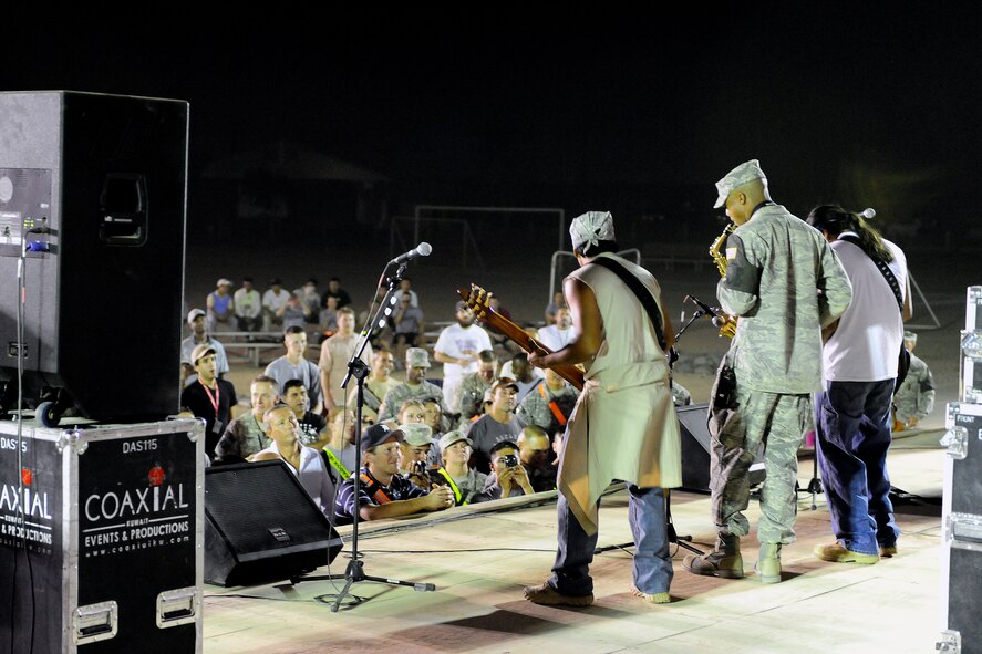 Kadena Airman 1st Class Theodore Wilkins, deployed from the 18th Security Forces Squadron and assigned to the 732nd Expeditionary SFS, plays the saxophone on stage with the Los Lonely Boys for a mixed crowd of Soldiers, Airmen, Sailors, and civilians at Contingency Operating Base Speicher, Iraq, Sept. 4, 2009. The Grammy Award winning Rock-N-Roll trio performed at COB Speicher as part of a military appreciation concert tour in the AOR. 
(U.S. Air Force photo by Staff Sgt. Luke P. Thelen/Released)