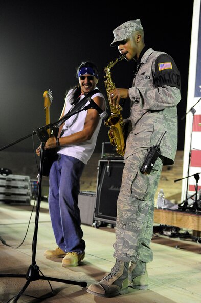 Kadena Airman 1st Class Theodore Wilkins, deployed from the 18th Security Forces Squadron and assigned to the 732nd Expeditionary SFS, plays the saxophone on stage with the Los Lonely Boys for a mixed crowd of Soldiers, Airmen, Sailors, and civilians at Contingency Operating Base Speicher, Iraq, Sept. 4, 2009. The Grammy Award winning Rock-N-Roll trio performed at COB Speicher as part of a military appreciation concert tour in the AOR. 
(U.S. Air Force photo by Staff Sgt. Luke P. Thelen/Released)