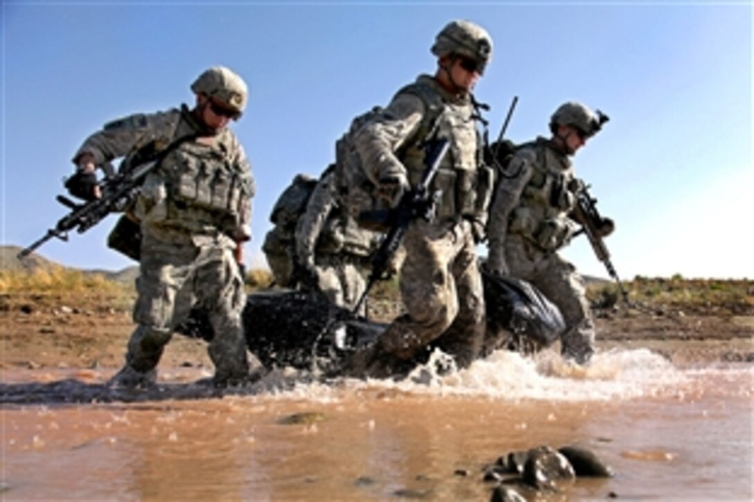 U.S. Army soldiers carry a bag filled with food and water that will sustain them while on a multi-day mission near Sar Howza in Paktika province, Afghanistan, Sept. 2, 2009. The soldiers, assigned to 1st Squadron, 40th Cavalry Regiment, will hide the bag until they return to gather and distribute the contents before moving to a different location. 