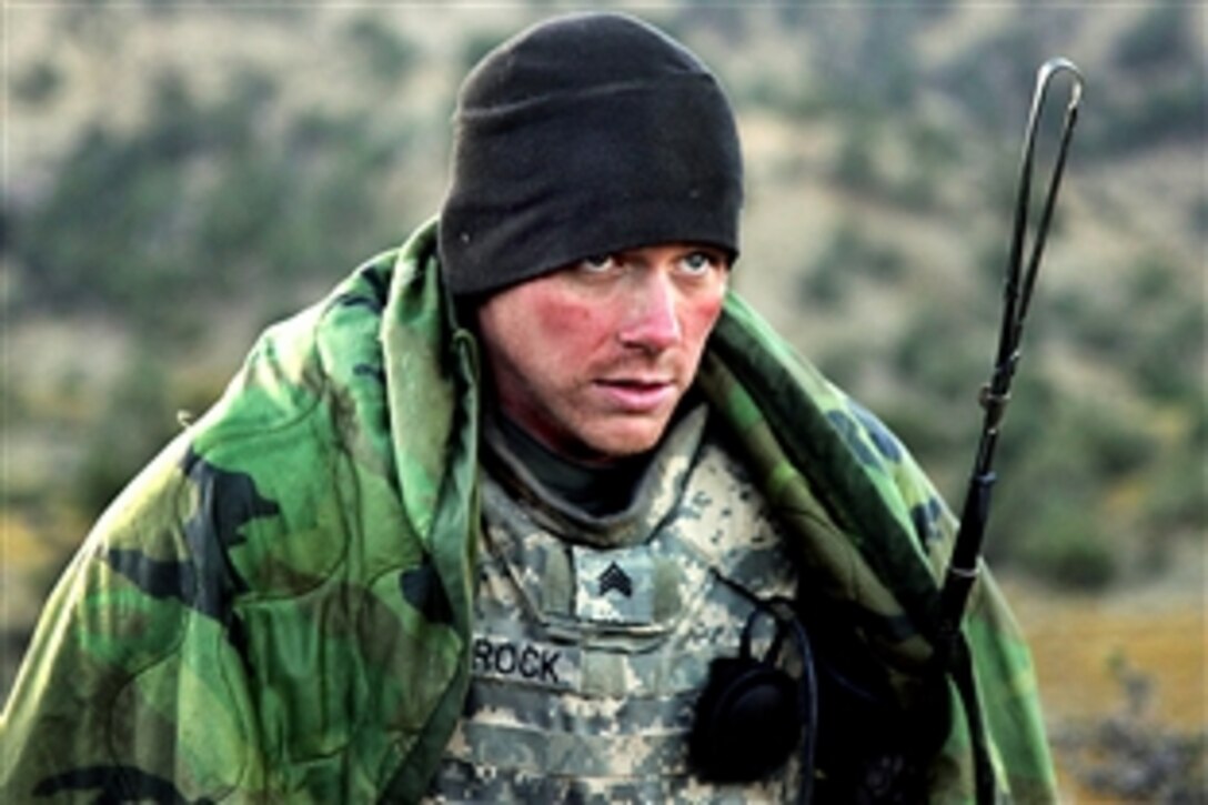 U.S. Army Sgt. Nathan Schrock tries to keep warm after waking up on a cold morning in the mountains near Sar Howza in Paktika province, Afghanistan, Sept. 4, 2009. Schrock is assigned to the 1st Squadron, 40th Cavalry Regiment. 