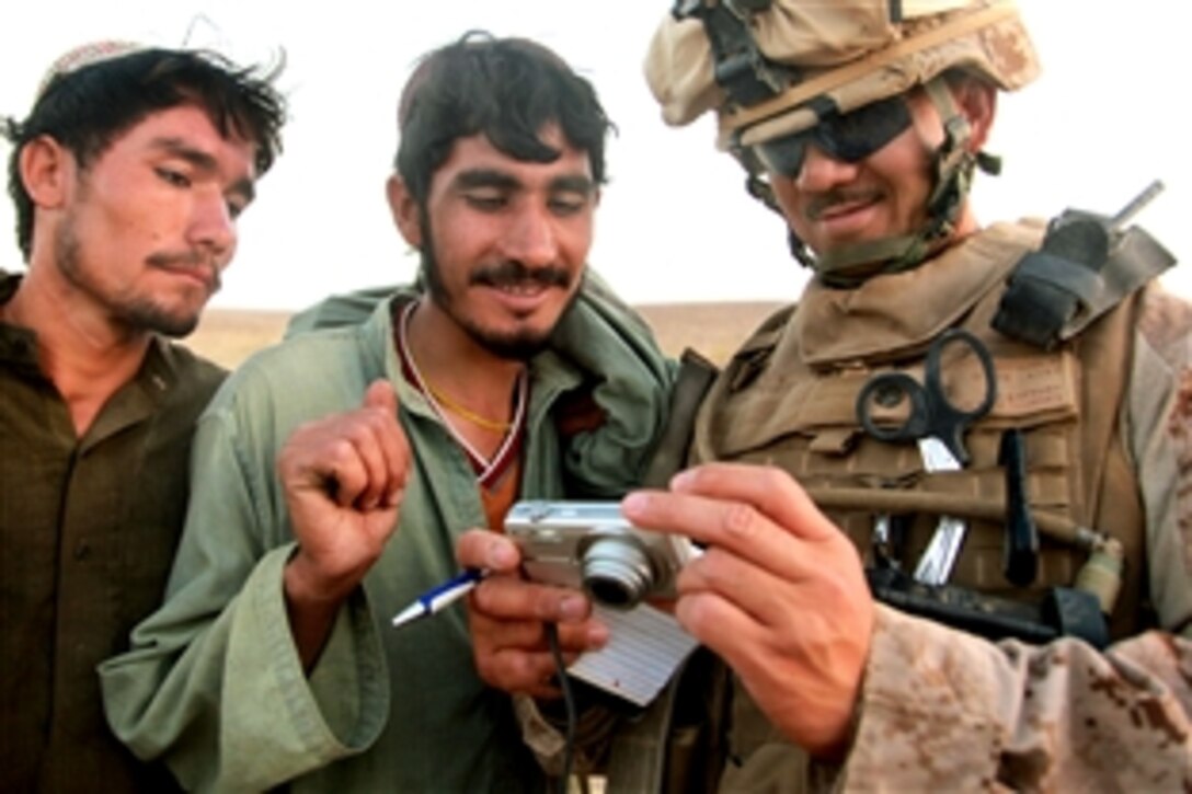 U.S. Navy Chief Petty Officer Angelito Campano shows Afghan citizens their photo during a medical civic action mission in Helmand province, Afghanistan, Sept. 1, 2009. Campano, the chief of Battalion Aid Station, is assigned to the 3rd Battalion, 11th Marine Regiment. The unit is deployed with Regimental Combat Team 3 to conduct counterinsurgency operations with Afghan national security forces in southern Afghanistan.


