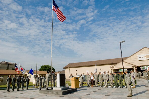 Servicemembers at Kunsan Air Base salute the U.S. flag during the September 11 Patriot Day Ceremony Sept. 11 at Kunsan Air Base, Republic of Korea. The ceremony is Kunsan's way of acknowledging the courageous firefighters, police officers, emergency responders and others who risked their lives to save the victims of the tragic events of September 11, 2001. The ceremony also paid tribute to the men and women of the U.S. Armed Forces who have served in the military whether deployed or at home station since these events. (U.S. Air Force photo/Senior Airman Jonathan Steffen) 