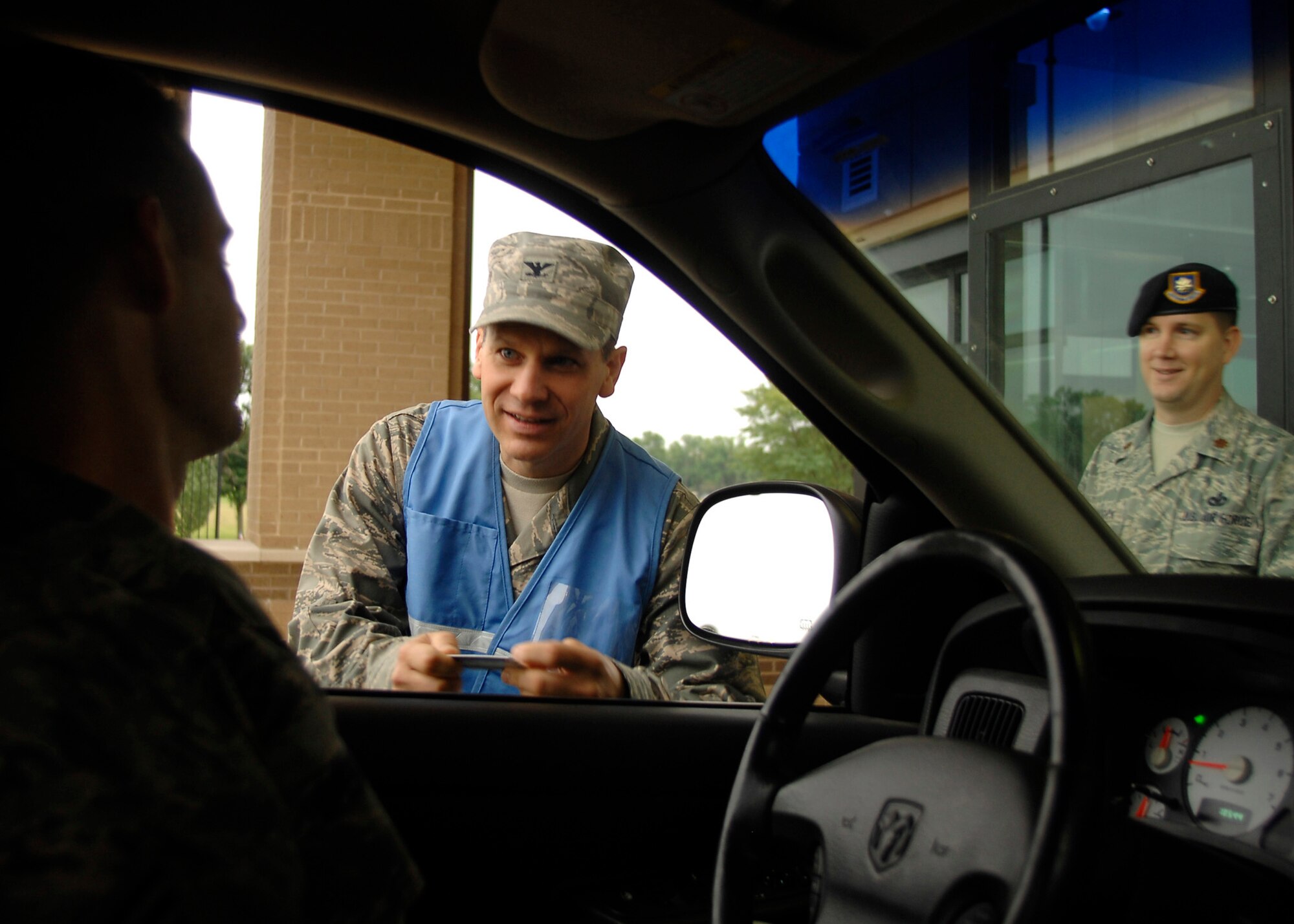 Col. James Crowhurst, 22nd Air Refueling Wing commander, and Maj. Kenneth Woodcock, acting 22nd Security Forces commander, check ID’s and provide safety messages Sept. 3 to drivers entering McConnell Air Force Base, Kan.  Base leadership and Airmen from the 22nd Air Refueling Wing safety office were posted at the gate to remind Team McConnell members to enjoy a safe Labor Day weekend. (U.S. Air Force photo/Senior Airman Anthony Mejia)