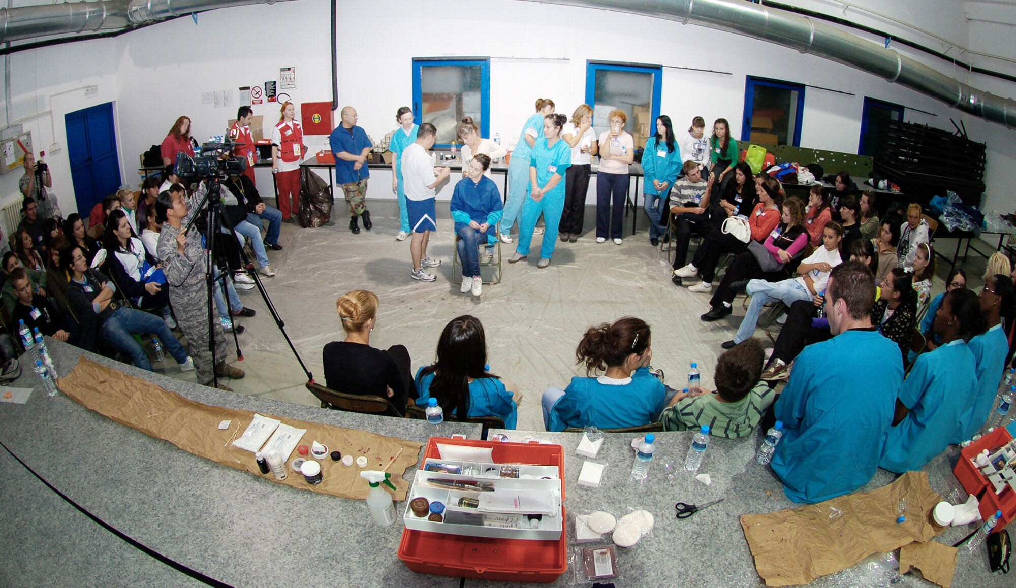 Students from Dr. Milenko Hadzic Medical School at Nis, Serbia, watch as Senior Master Sgt. Juan Gomez, 86th Medical Group from Ramstein Air Base Germany, applies a moulage gunshot wound to the neck of a classmate Sept. 8 during a moulage class. Airmen from the 86th Medical Group provided the training to medical students who participated as mock patients in a mass casualty exercise during the live exercise portion of the military medical training exercise in Central and Eastern Europe, or MEDCEUR 2009. (U.S. Air Force photo/Senior Airman Kali L. Gradishar)