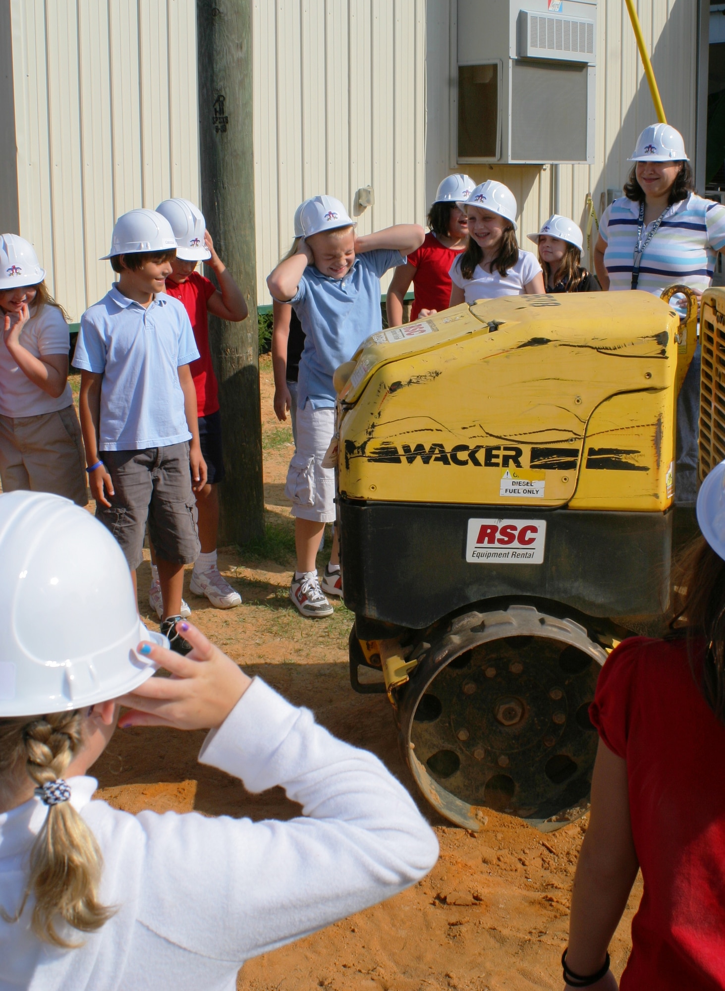 Tyndall Elementary students from kindergarten to fifth grade explore construction equipment outside the school Sept. 10.  The children and staff all wore thunderbird hard hats to witness the heavy machinery in action.   (U.S. Air Force photo/ Tanya Schiller)