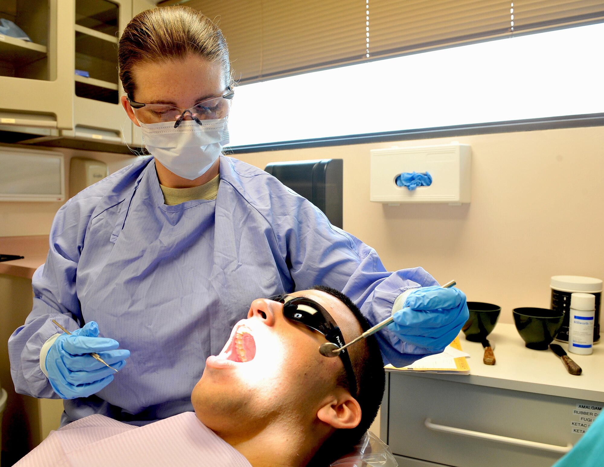 SHAW AIR FORCE BASE, S.C. -- Lieutenant Col. Kathleen Gates, 20th Dental Squadron commander, examines Airman Ruben Acuna, 20th Equipment Maintenance Squadron, Sept. 9. "My goal is to provide the best possible dental care to our patients," she said. "Internally, my desire is to make sure that the squadron membership has the resources  they need to take care of each other and themselves." (U.S. Air Force photo/Senior Airman Kathrine McDowell)