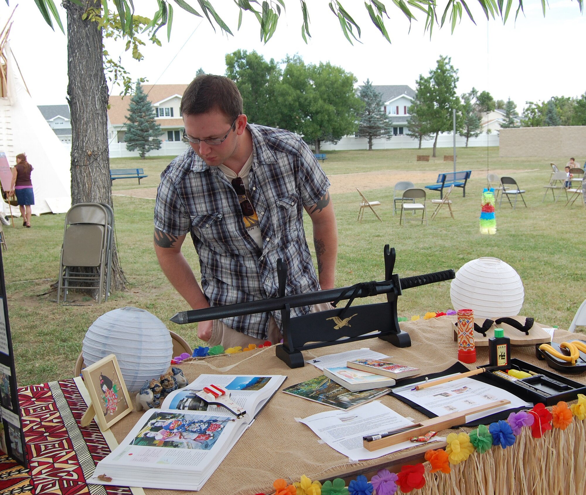 Staff Sgt. Josh Bargas, 341st Security Forces Squadron, looks over items on display at the American Samoa information booth at the Multi-Cultural Celebration Sept. 3. This first-ever event was held at the Grizzly Bend Club and brought together Team Malmstrom members of all cultures and backgrounds. (U.S. Air Force photo/Valerie Mullett)