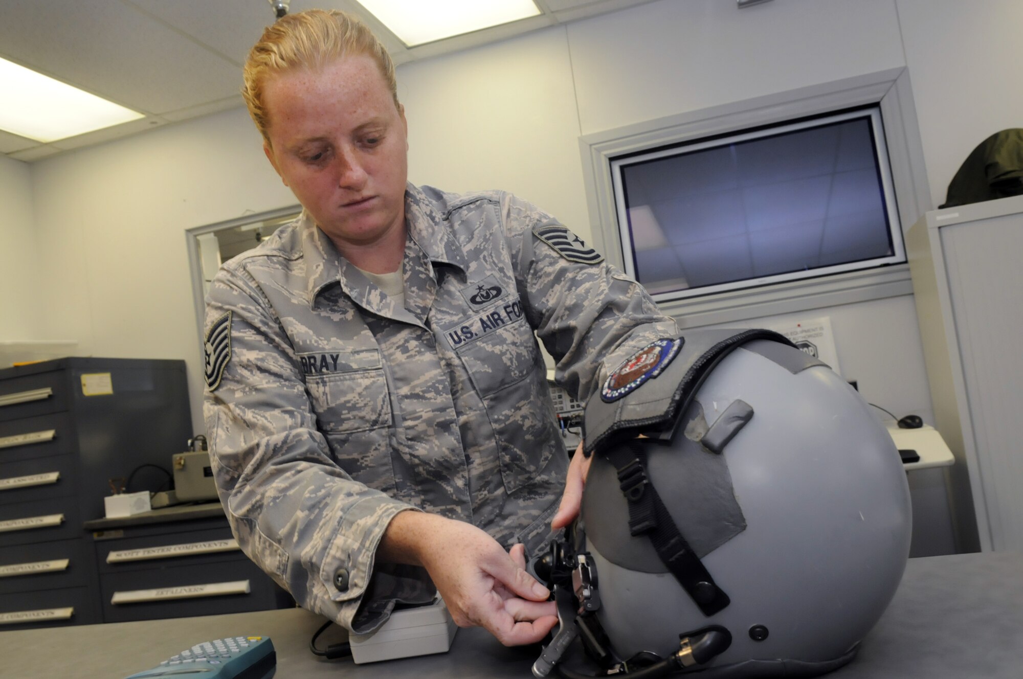 TSgt. Brandi Bray, aircrew flight equipment technician, checks the microphone and headset and does a calibration check on a flight helmet. U. S. Air Force photo by Sue Sapp