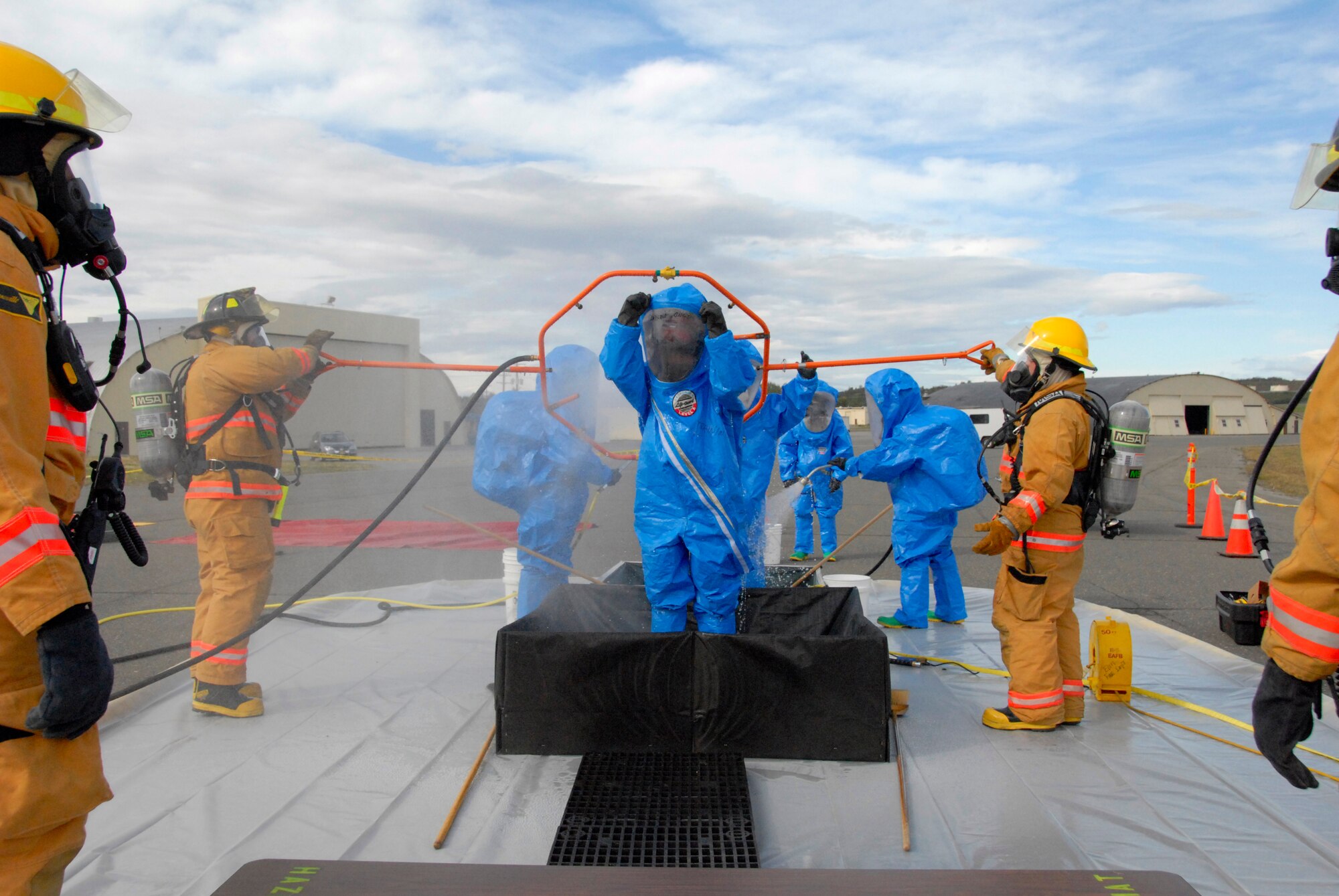 ELMENDORF AIR FORCE BASE, Alaska -- Firefighters run through decontamination procedures during an all hazards response training exercise Sept. 9 at Hangar 5. Firefighters were instructed to maintain an "all hazards" mentality to ensure a more accurate example of how they would carry out the exercise. (U.S. Air Force photo/Senior Airman Cynthia Spalding)