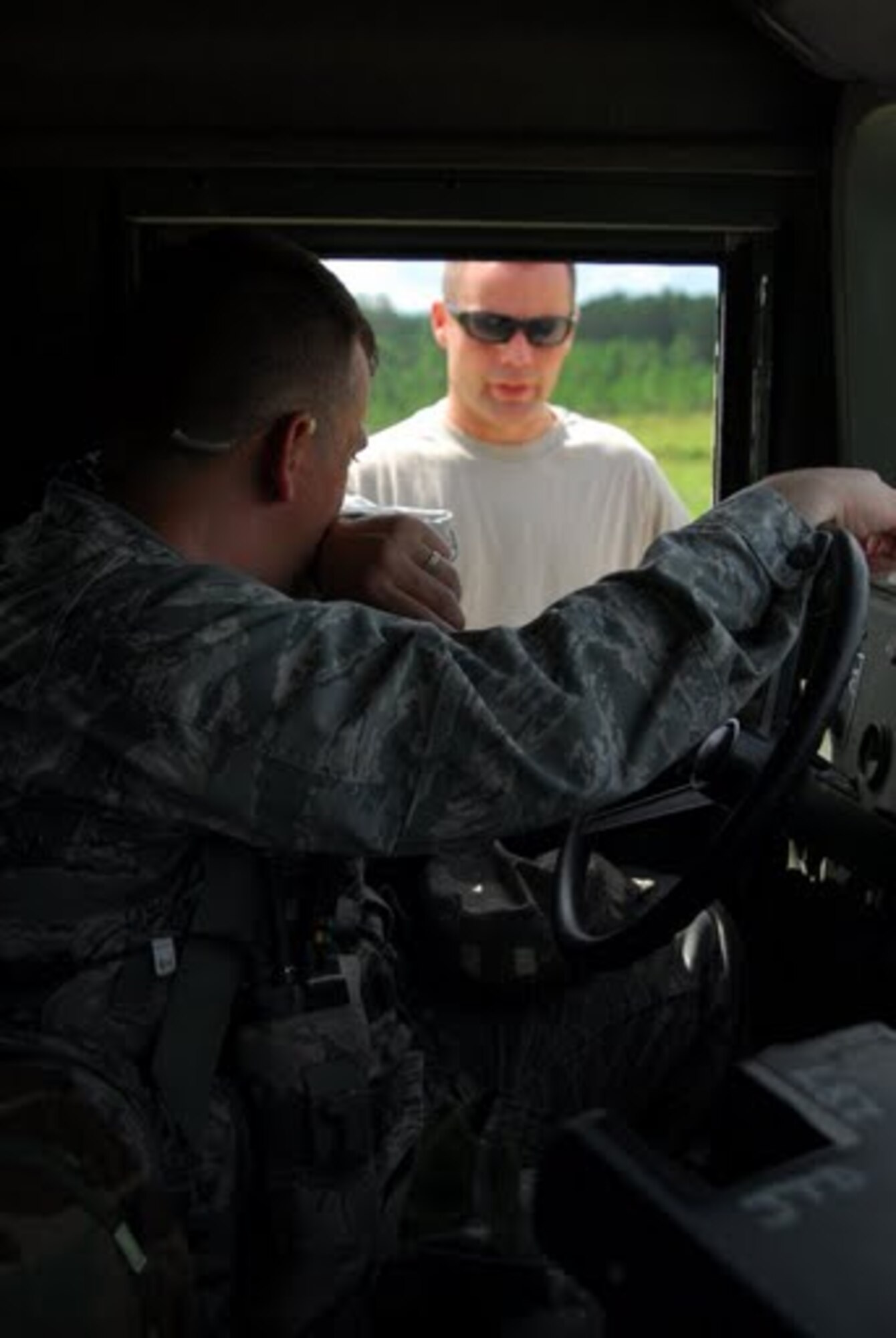 An Army Sergeant from the 5th aviation battalion, and Capt. Robert Hammontree, a 34th Combat Training Squadron air mobility liaison officer assigned to Ft. Polk, La., listen to radio communications prior to a supply drop Aug. 21 at the Joint Readiness Training Center Ft. Polk, La. As an AMLO, the captain was responsible for providing communications between Air Force aircrews and Army ground forces during Green Flag Little Rock exercise 09-09. (U.S. Air Force photo by Staff Sgt. Juan Torres)