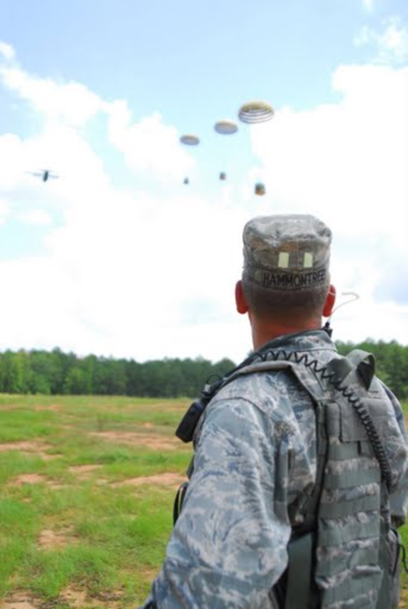 Capt. Robert Hammontree, 34th Combat Training Squadron air mobility liaison officer assigned to Ft. Polk, La., watches as supplies dropped by a Belgian C-130 land on the drop zone. Aircrews that participated in Green Flag Little Rock experienced missions in a simulated combat enviroment with an emphasis on joint and coalition interoperability and communications. (U.S. Air Force photo by Staff Sgt. Juan Torres)