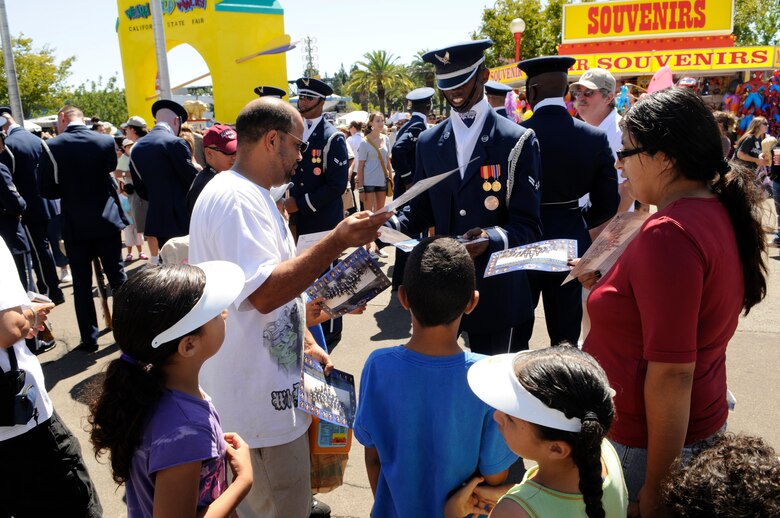 Airman 1st Class Joshua Drake, United States Air Force Honor Guard Drill Team, signs autographs after a 16-man performance Sept. 6 at the California State fair in Sacramento. The Drill Team performed five times at the state fair which drew crowds of more than 675,000 people. The Drill Team, the traveling component of the Honor Guard, tours around the world in order to recruit, retain, and inspire. ((U.S. Air Force photo by Staff Sgt. Dan DeCook) 