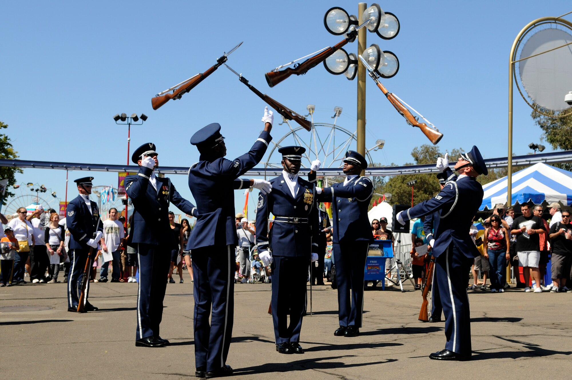 Members of the United States Air Force Honor Guard Drill Team’s four-man team throw “overs” Sept. 6 at the California State fair in Sacramento. The Drill Team performed five times at the state fair which drew crowds of more than 675,000 people. The Drill Team, the traveling component of the Honor Guard, tours around the world in order to recruit, retain, and inspire. (U.S. Air Force photo by Staff Sgt. Dan DeCook)