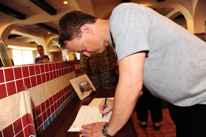NELLIS AIR FORCE BASE, Nev. -- Mr.Gary Sinise signs a guest book after enjoying breakfast at the Crosswinds Dining Facility, Sept. 7.  Mr. Sinise visited Nellis Airmen and toured various agencies on base. (U.S. Air Force photo by Staff Sgt. William Coleman)
