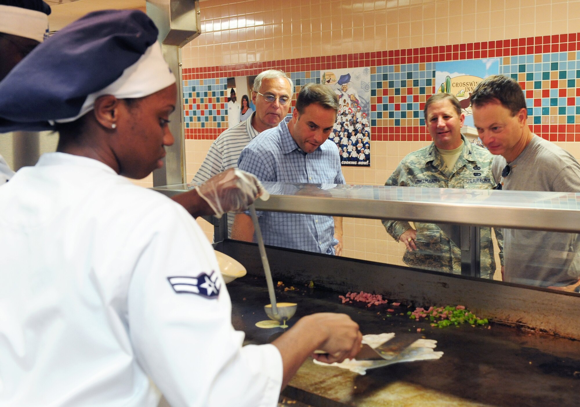 Nellis Air Force Base, Nev. -- Airman 1st Class Tiffany Simmonds, a service apprentice assigned to the 99th Force Support Squadron, prepares an omelet for Gary Sinise at the Crosswinds Dining Facility, Sept. 7. Mr. Sinise visited Nellis Airmen and was accompanied by Col. Steven Winklmann, 99th Air Base Wing vice commander, and Chief Master Sgt. Alfred Herring, 99th Air Base Wing command chief.  
(U.S. Air Force photo by Staff Sgt. William Coleman)