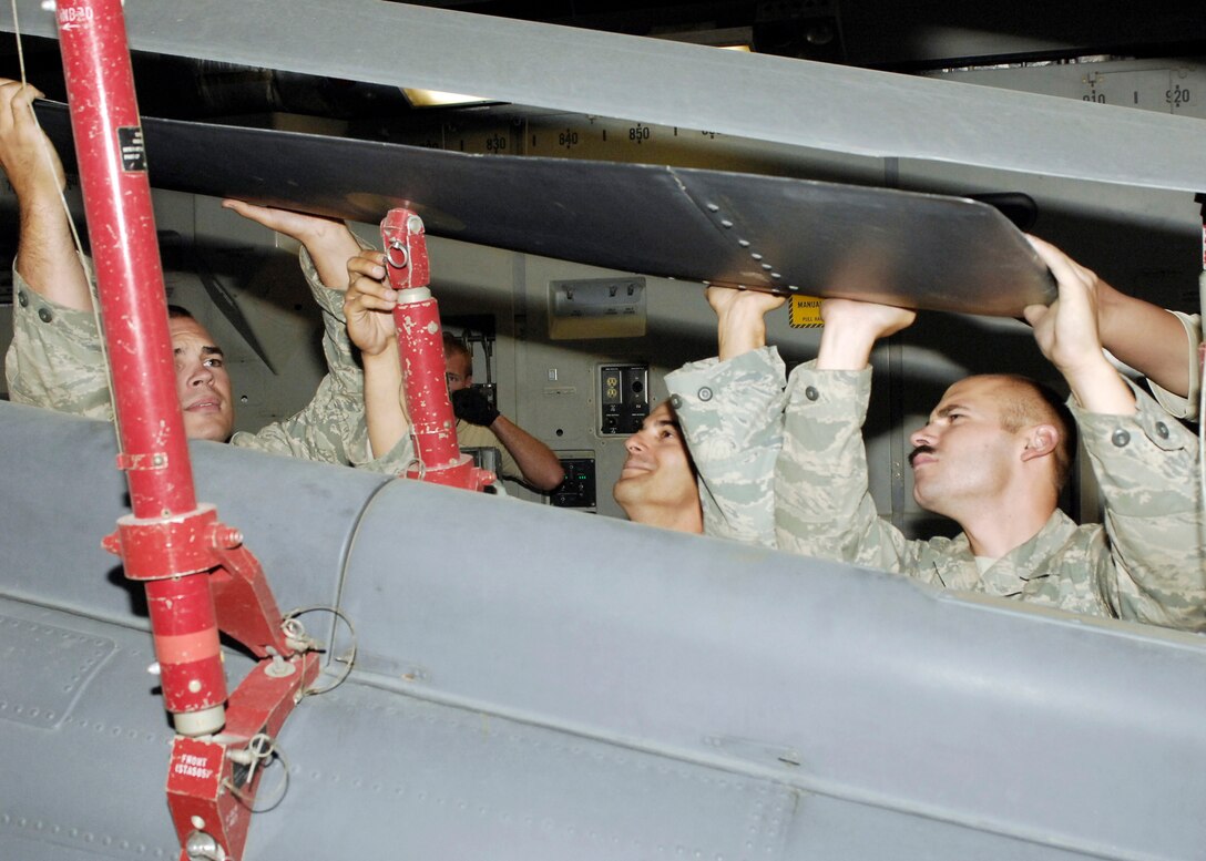 Senior Airman Josh Berge (left to right), Staff Sgt. Elias Carlon and Senior Airman Anthony Boone work together to ensure a HH-60G Pave Hawk doesn't sustain any damage by securing the rotors Sept. 9, 2009, at Bagram Airfield, Afghanistan. The Pave Hawk is loaded onto a C-17 Globemaster III for its return to home station. All three Airmen are from the 455th Expeditionary Aircraft Maintenance Squadron and deployed from Royal Air Force Lakenheath, England. (U.S. Air Force photo/Senior Airman Felicia Juenke)