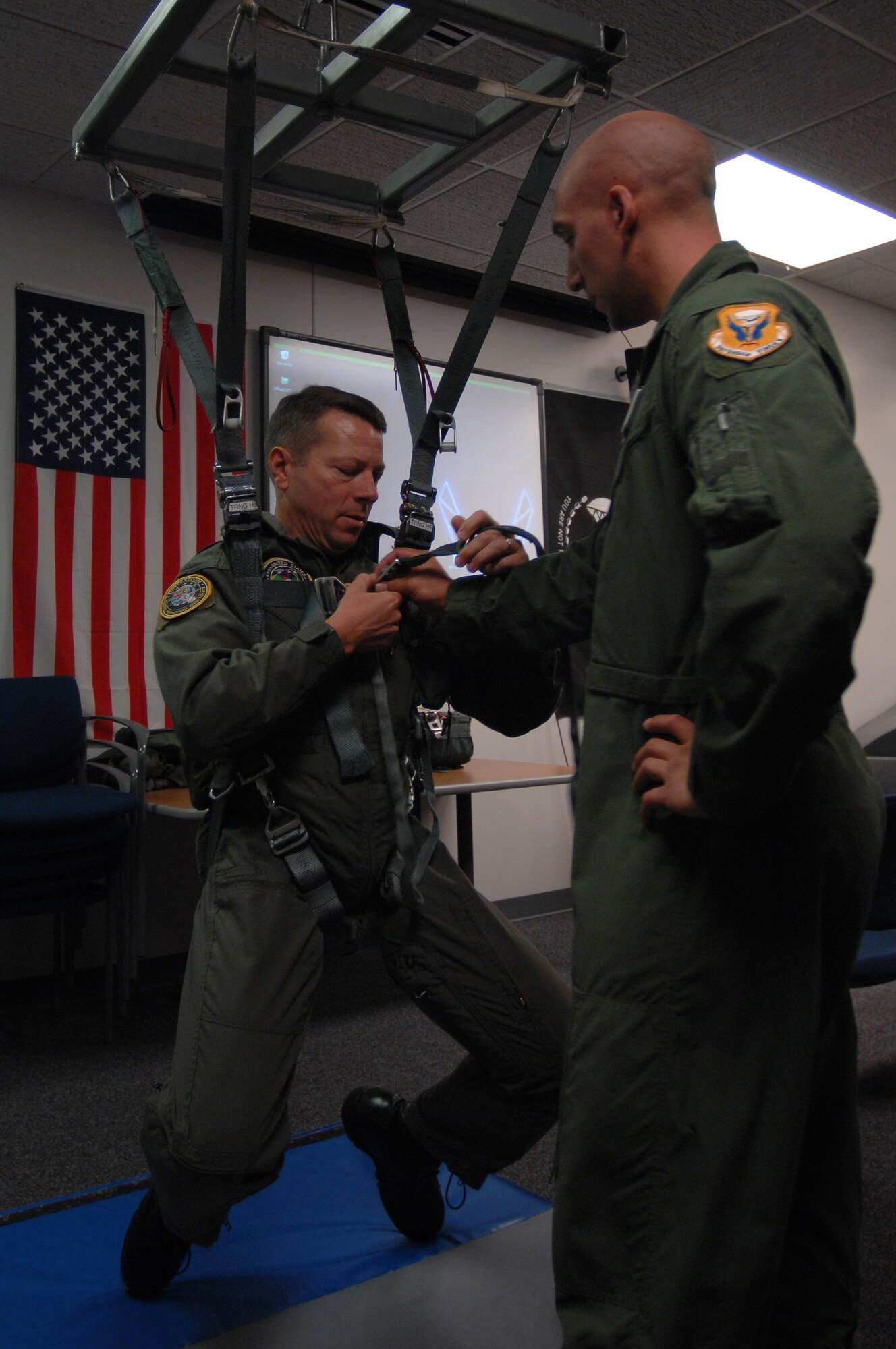 WHITEMAN AIR FORCE BASE, Mo. - Brig. Gen. Joseph Brown, deputy director for Nuclear Operations, U.S. Strategic Command (left), is instructed by Staff Sgt. Michael Garcia, 509th Operations Support Squadron search and rescue specialist, during egress training prior to flight, Sept. 8. General Brown visited to Whiteman for three days to fly the B-2 Spirit and discuss nuclear operations and procedures with enlisted and officer personnel. (U.S. Air Force photo/Senior Airman Kenny Holston)