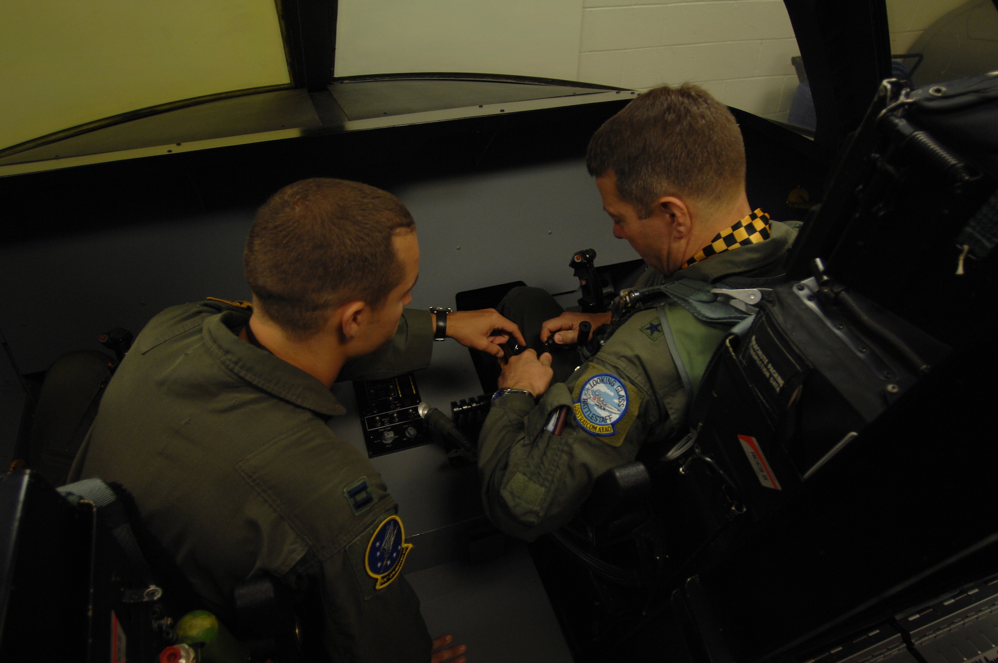WHITEMAN AIR FORCE BASE, Mo. - Capt. Jay Morgan, 509th Operations Support Squadron egress instructor, gives Brig. Gen. Joseph Brown, deputy director for Nuclear Operations, U.S. Strategic Command, a few extra tips in the B-2 Spirit simulator during egress training prior to General Brown's first B-2  Spirit flight, Sept. 8. General Brown visited to Whiteman for three days to fly the B-2 Spirit and discuss nuclear operations and procedures with enlisted and officer personnel. (U.S. Air Force photo/Senior Airman Kenny Holston)