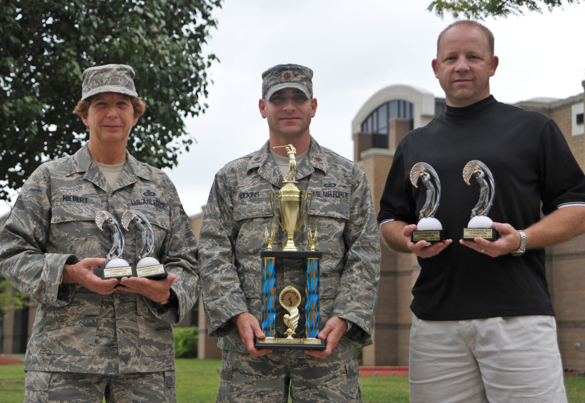 Maj. Colin Huckins presents trophies to Senior Master Sgt. Diane Hiebert and Tech. Sgt. Darren Horton (on right) as representatives of the 931st Air Refueling Group intramural golf team. The 931st team earned first place in the McConnell Air Force Base intramural league for the second year in a row. Major Huckins the commander of the 22nd Force Support Squadron at McConnell. (U.S. Air Force photo/Tech. Sgt. Jason Schaap)