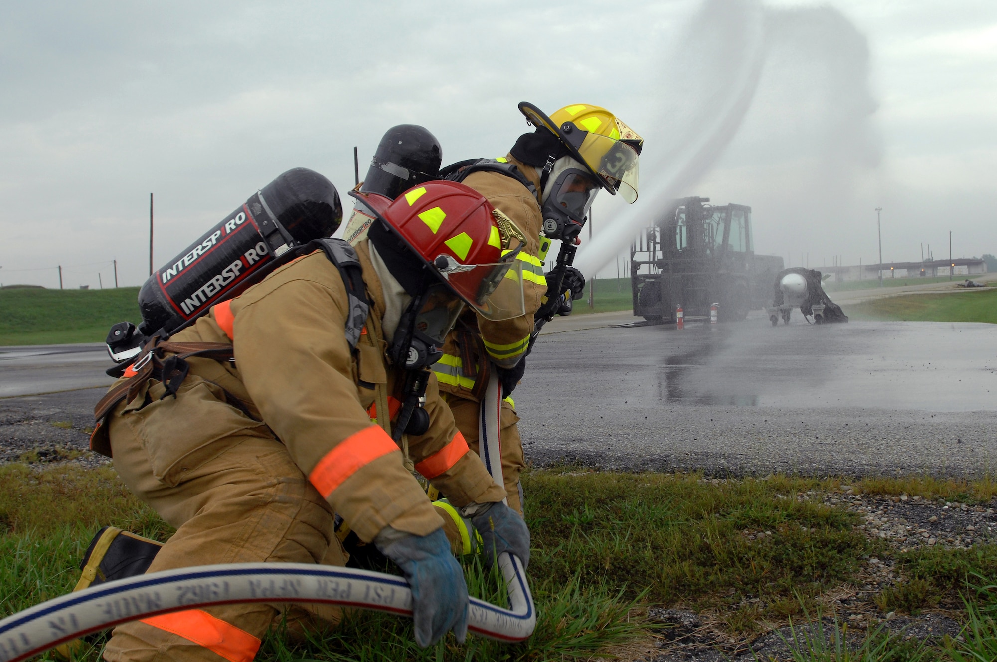 WHITEMAN AIR FORCE BASE, Mo. - Airman 1st Class Timothy Vanden Haak and Tech. Sgt. Ben Hosbein, 509th Civil Engineer Squadron firefighters, work together to extinguish a simulated weapons fire during a Mass Accident Response Exercise, Sept. 9. Airmen participating in the exercise were faced with a weapons transport that had come under enemy fire, resulting in injured casualties, a contamination spill and an ignited B-61 missile.  Firefighters, security forces, medical, explosive ordinance and munitions personnel all played major roles in the exercise to successfully complete all tasks and meet training requirements. (U.S. Air Force photo/Senior Airman Kenny Holston) 