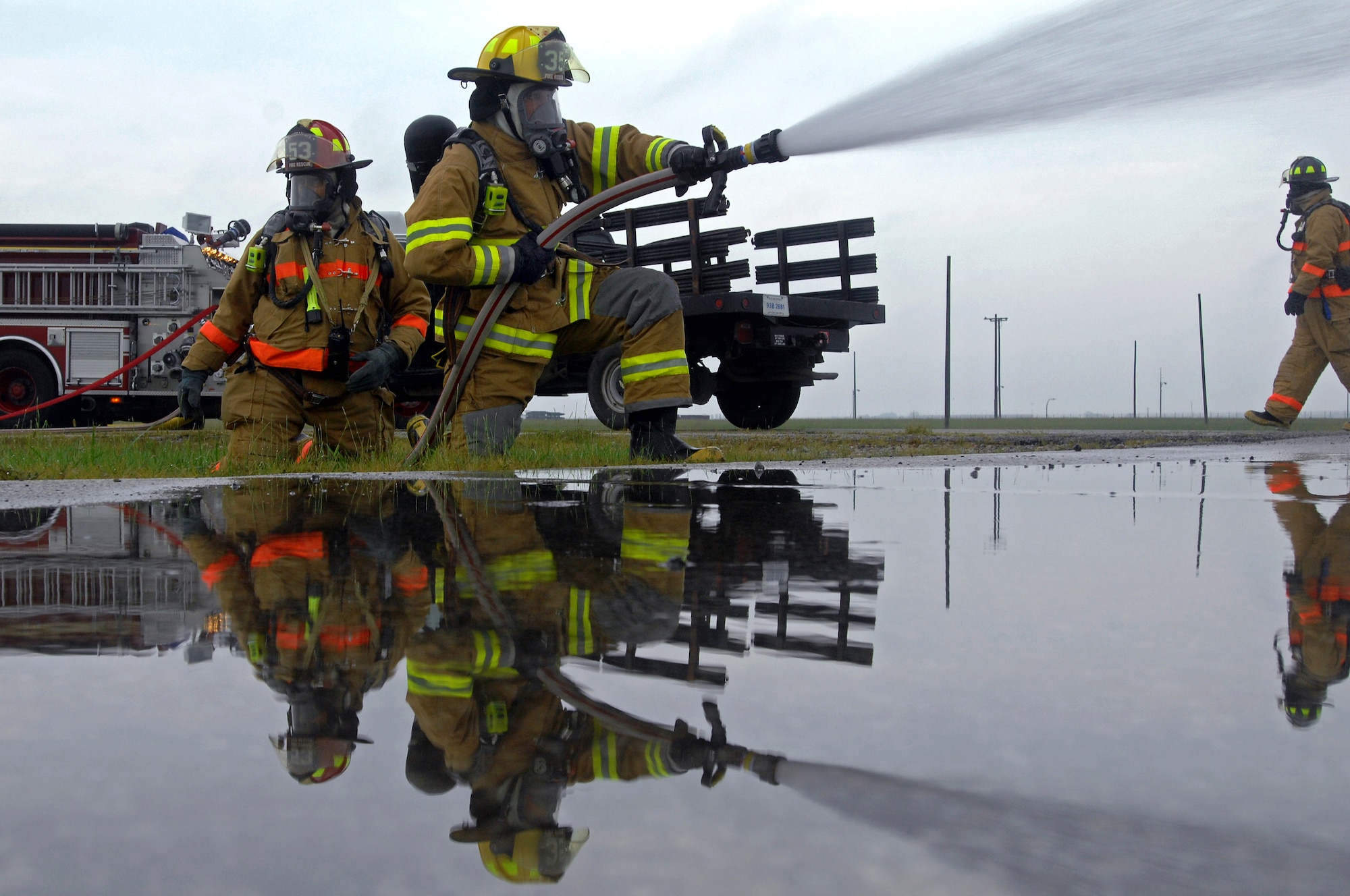 WHITEMAN AIR FORCE BASE, Mo. - Airman 1st Class Timothy Vanden Haak (center) holds steady while extinguishing a simulated weapons fire during a Mass Accident Response Exercise, Sept. 9. Airmen participating in the exercise were faced with a weapons transport that had come under enemy fire, resulting in injured casualties, a contamination spill and an ignited B-61 missile.  Firefighters, security forces, medical, explosive ordinance and munitions personnel all played major roles in the exercise to successfully complete all tasks and meet training requirements. (U.S. Air Force photo/Senior Airman Kenny Holston) 