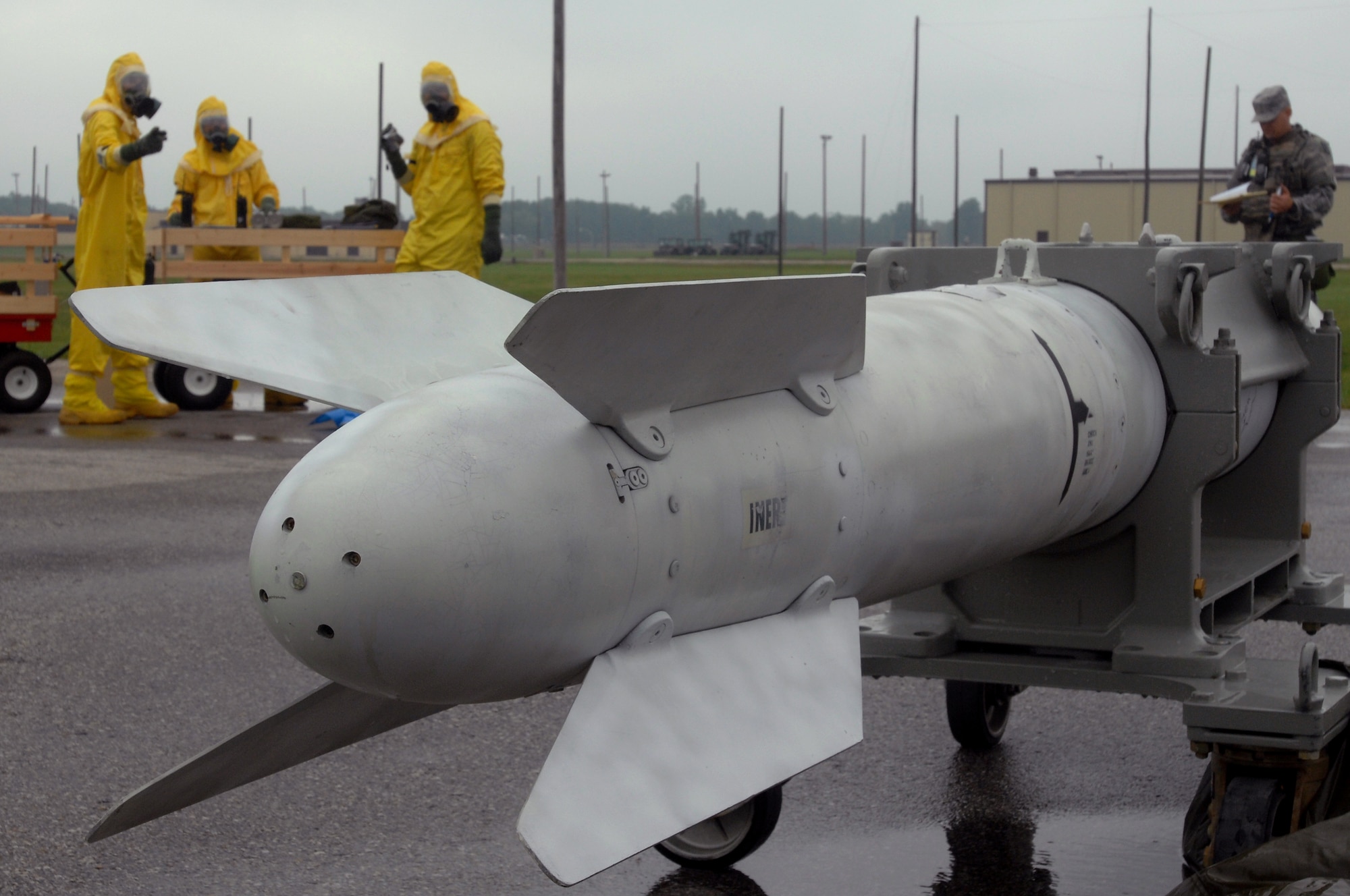 WHITEMAN AIR FORCE BASE, Mo. - (From left) Airman 1st Class Joshua Miller, Senior Airman Andrew Riddle and Staff Sgt. Angelo Giannosa, all 509th Civil Engineer Squadron explosive ordinance technicians, discuss their first move prior to assessing a B-61 missile for contamination during a Mass Accident Response Exercise, Sept. 9. Airmen participating in the exercise were faced with a weapons transport that had come under enemy fire, resulting in injured casualties, a contamination spill and an ignited B-61 missile.  Firefighters, security forces, medical, explosive ordinance and munitions personnel all played major roles in the exercise to successfully complete all tasks and meet training requirements. (U.S. Air Force photo/Senior Airman Kenny Holston) 