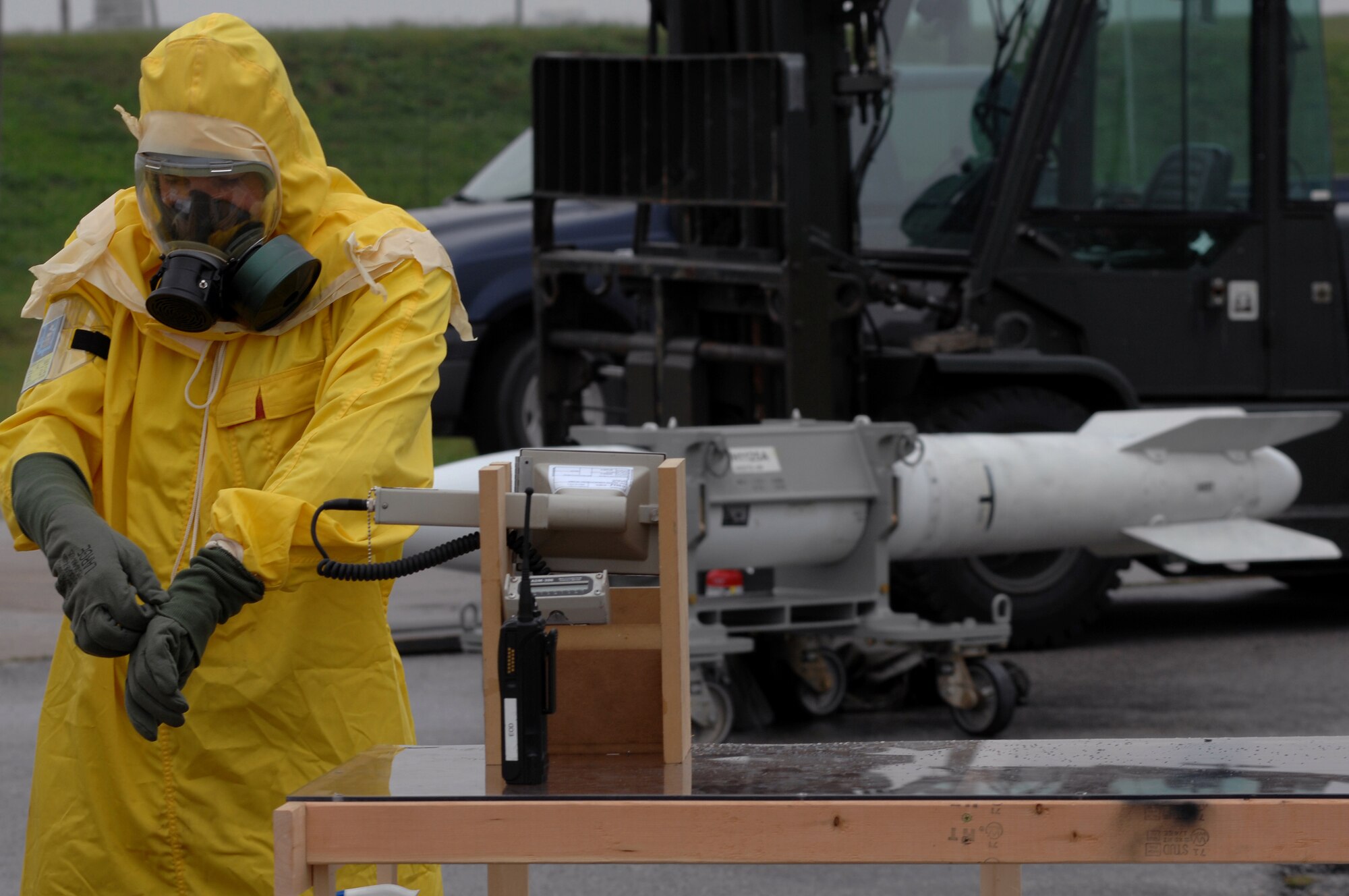 WHITEMAN AIR FORCE BASE, Mo. - Airman 1st Class Joshua Miller, 509th Civil Engineer Squadron explosive ordinance technician, pulls on his gloves in preparation to assess a B-61 missile for contamination during a Mass Accident Response Exercise, Sept. 9. Airmen participating in the exercise were faced with a weapons transport that had come under enemy fire, resulting in injured casualties, a contamination spill and an ignited B-61 missile.  Firefighters, security forces, medical, explosive ordinance and munitions personnel all played major roles in the exercise to successfully complete all tasks and meet training requirements. (U.S. Air Force photo/Senior Airman Kenny Holston) 