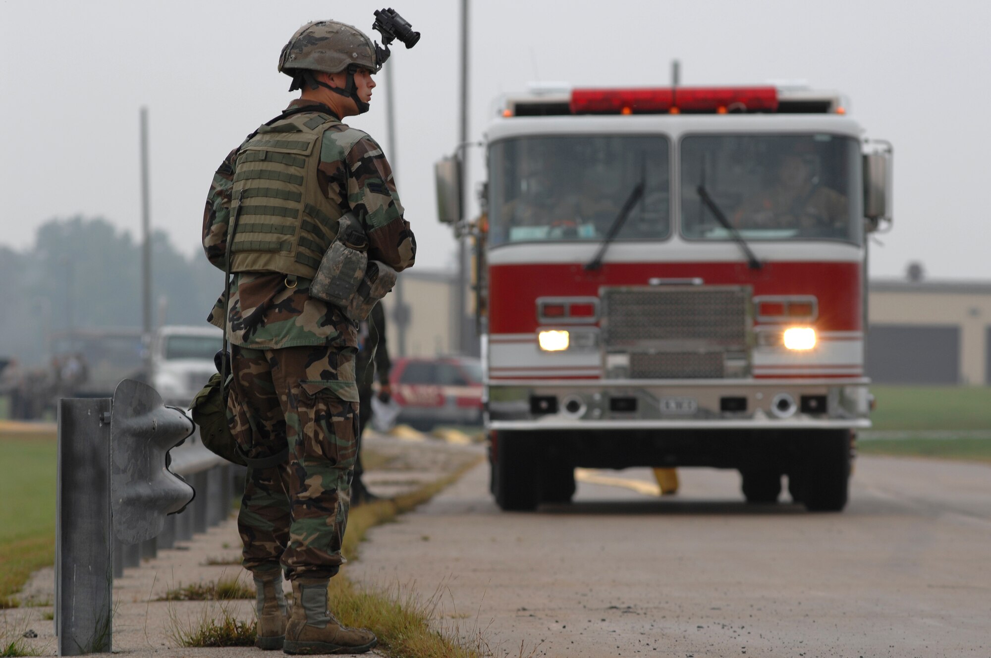 WHITEMAN AIR FORCE BASE, Mo. - Airman 1st Class Corey Koch, 509th Security Forces Squadron, guards the perimeter of a contaminated area as a 509th Civil Engineer Squadron fire crew approaches the entry control point of the area to assist crews already on-scene during a Mass Accident Response Exercise, Sept. 9. Airmen participating in the exercise were faced with a weapons transport that had come under enemy fire, resulting in injured casualties, a contamination spill and an ignited B-61 missile.  Firefighters, security forces, medical, explosive ordinance and munitions personnel all played major roles in the exercise to successfully complete all tasks and meet training requirements. (U.S. Air Force photo/Senior Airman Kenny Holston) 