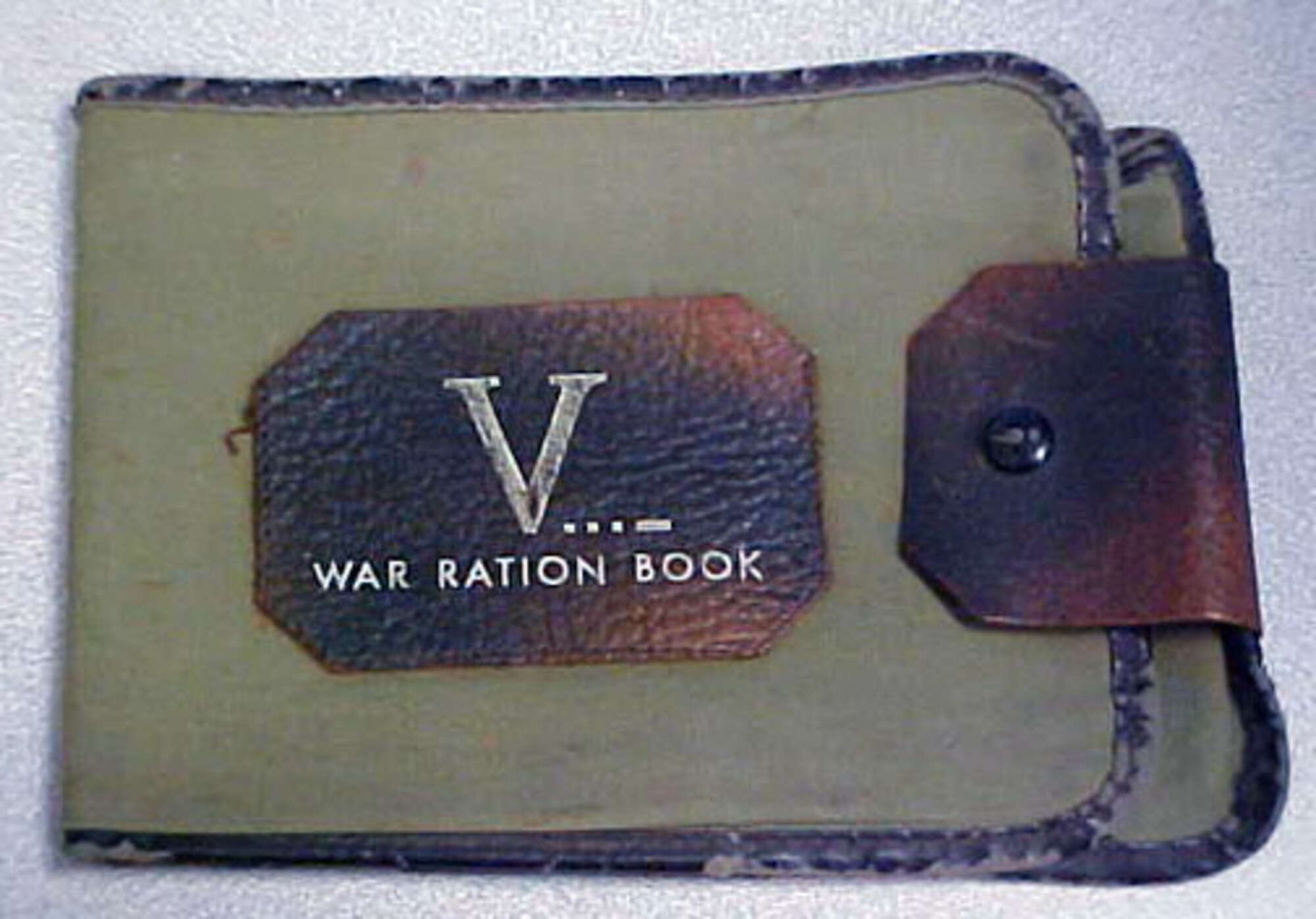 This olive drab cloth and brown leather wallet-style book was used for holding war rations. (U.S. Air Force photo)