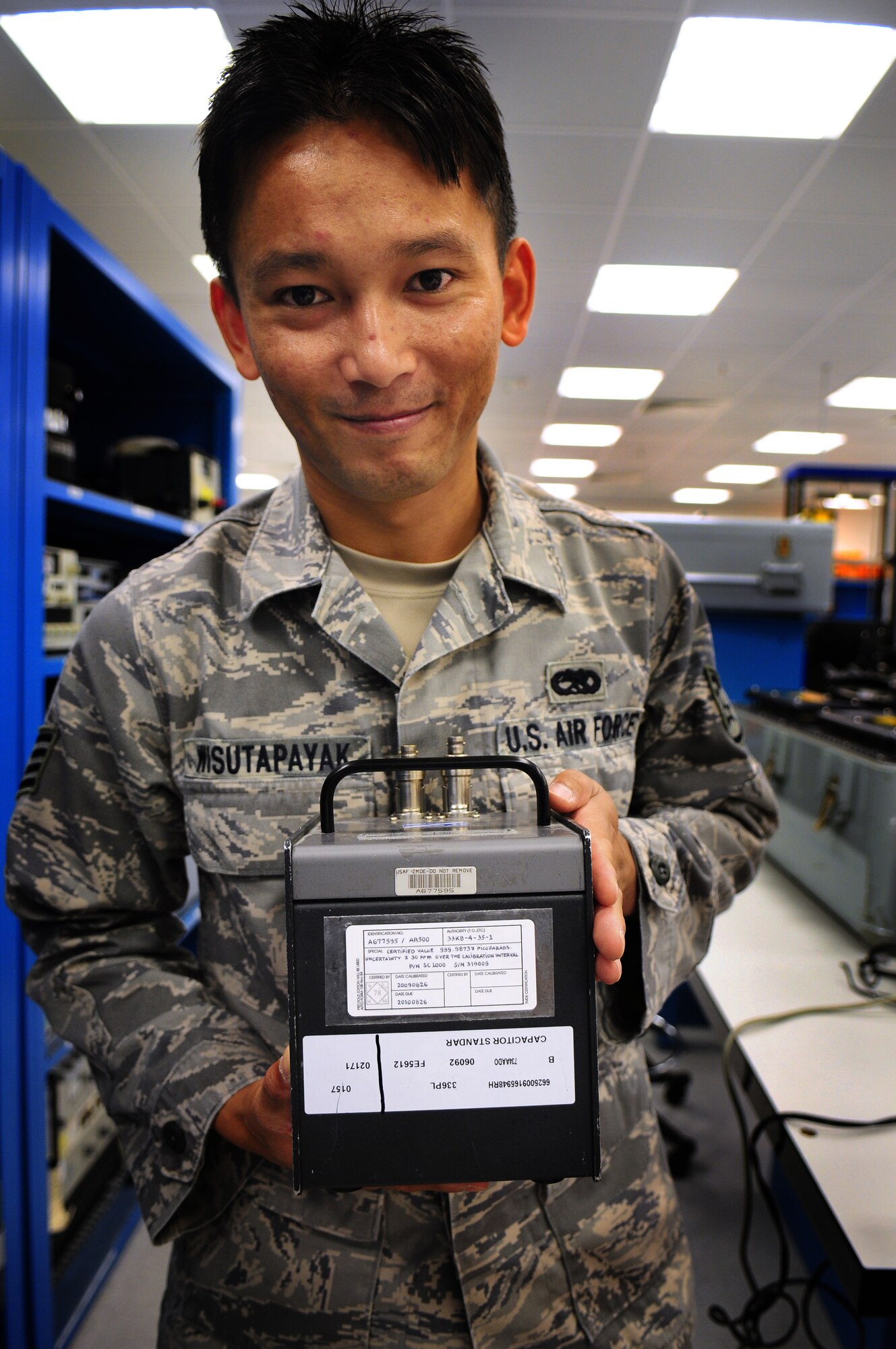 U.S. Air Force Staff Sgt. Jirayu Wisutapayak, 86th Maintenance Squadron precision measurement equipment laboratory technician, shows off his handwriting skills on an equipment label.  Sergeant Wisutapayak, originally from Thailand, joined the U.S. Air Force in 2002 after working in a Thailand library, using his handwriting abilities to label books since the library did not have typewriters or computers. (U.S. Air Force photo by Staff Sgt. Jocelyn Rich)  