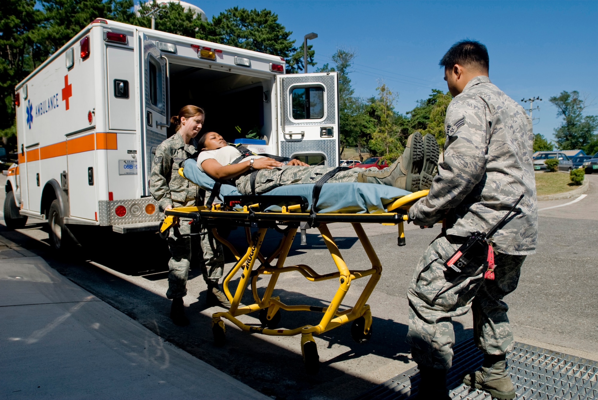 KUNSAN AIR BASE, Republic of Korea --Tech. Sgt. Samantha Mosher and Senior Airman John Reyes, 8th Medical Operations Squadron, lift a gurney with Senior Airman Ktreese Rodriguez as a simulated patient Sept. 10. Sergeant Mosher and Airman Reyes are emergency medical technician (EMT) qualified aerospace medical technicians assigned to ambulance services. Ambulance services primary duties are to respond to 911 calls, in-flight emergencies and sick call. (U.S. Air Force photo/ Senior Airman Jonathan Steffen) 