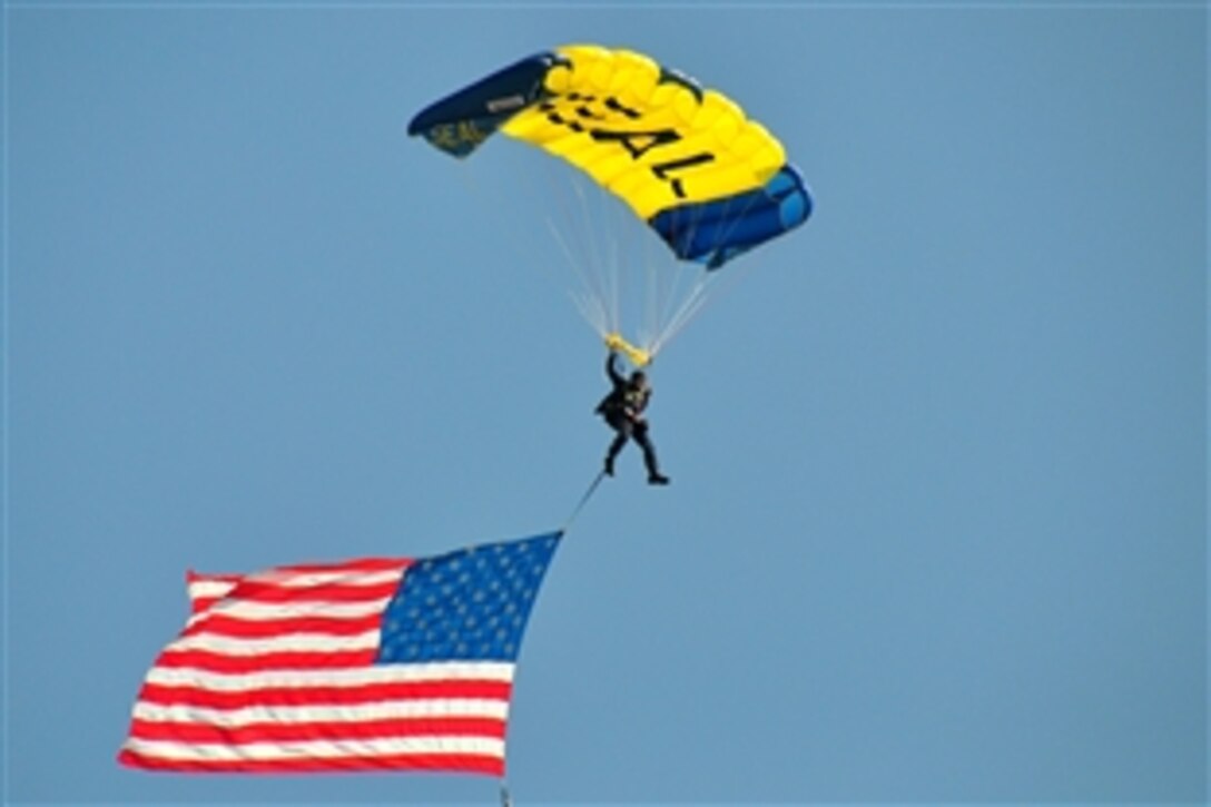 A leap frog from the U.S. Navy Parachute Team parachutes with the American flag onto the Naval Base San Diego football field in San Diego, Calif., Sept. 9, 2009. Six Leap Frogs parachuted onto the base to start the 23rd Annual POW/MIA 5-kilometer run and 1-mile walk.