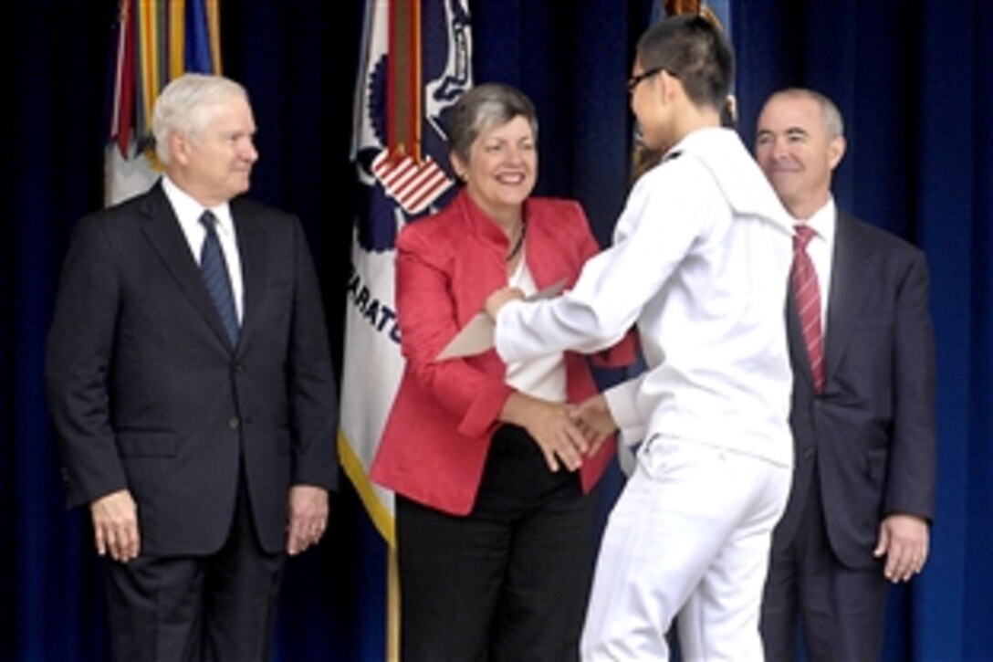 From left to right, Defense Secretary Robert M. Gates, Homeland Security Secretary Janet Napolitano and Alejandro Mayorkas, director of the U.S. Citizenship and Immigrration Service, congratulate one of 31 immigrant U.S. military personnel who took the oath of office in the Pentagon courtyard, Sept. 10, 2009. The new U.S. citizens represented all branches of the service and 20 different countries of origin.