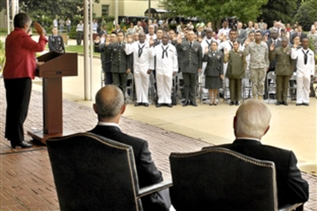 Homeland Security Secretary Janet Napolitano administers the oath of allegiance to 31 immigrant military service personnel representing 20 different countries of origin during a naturalization ceremony in the Pentagon courtyard, Sept. 10, 2009. Defense Secretary Robert M. Gates, seated right with Alejandro Mayorkas, director of the U.S. Citizenship and Immigration Service, later addressed the new citizens, family members and guests.