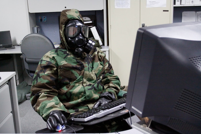 A Marine Aircraft Group 12 Marine in Building 1 here attempts to work on his computer while attired in his mission oriented protective posture gear during a training exercise which involved Marines here and in Kadena Air Base Okinawa, Japan Sep. 10. The exercise gave MAG-12 Marines the opportunity to experience what it’s like to do their jobs while attired head to toe in their MOPP gear.