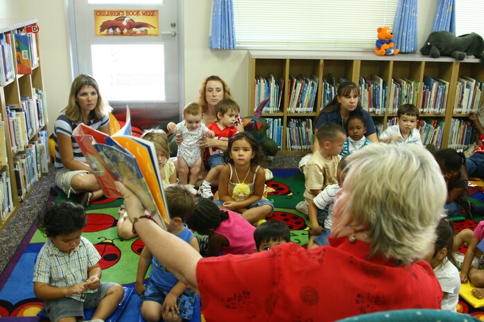 Parents and children gather around Belinda J. Pugh, supervisory librarian for the station library, as she reads one of many books during the Story Time class held in the children’s room of the station library here. Story Time is an hour-long class held in the children’s room every Thursday at 10 a.m. It is open to all children age 5 and younger to help promote reading.
