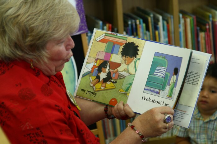 Belinda J. Pugh, supervisory librarian for the station library, reads a book to parents with their children during a Story Time class held in the children’s room of the station library here.