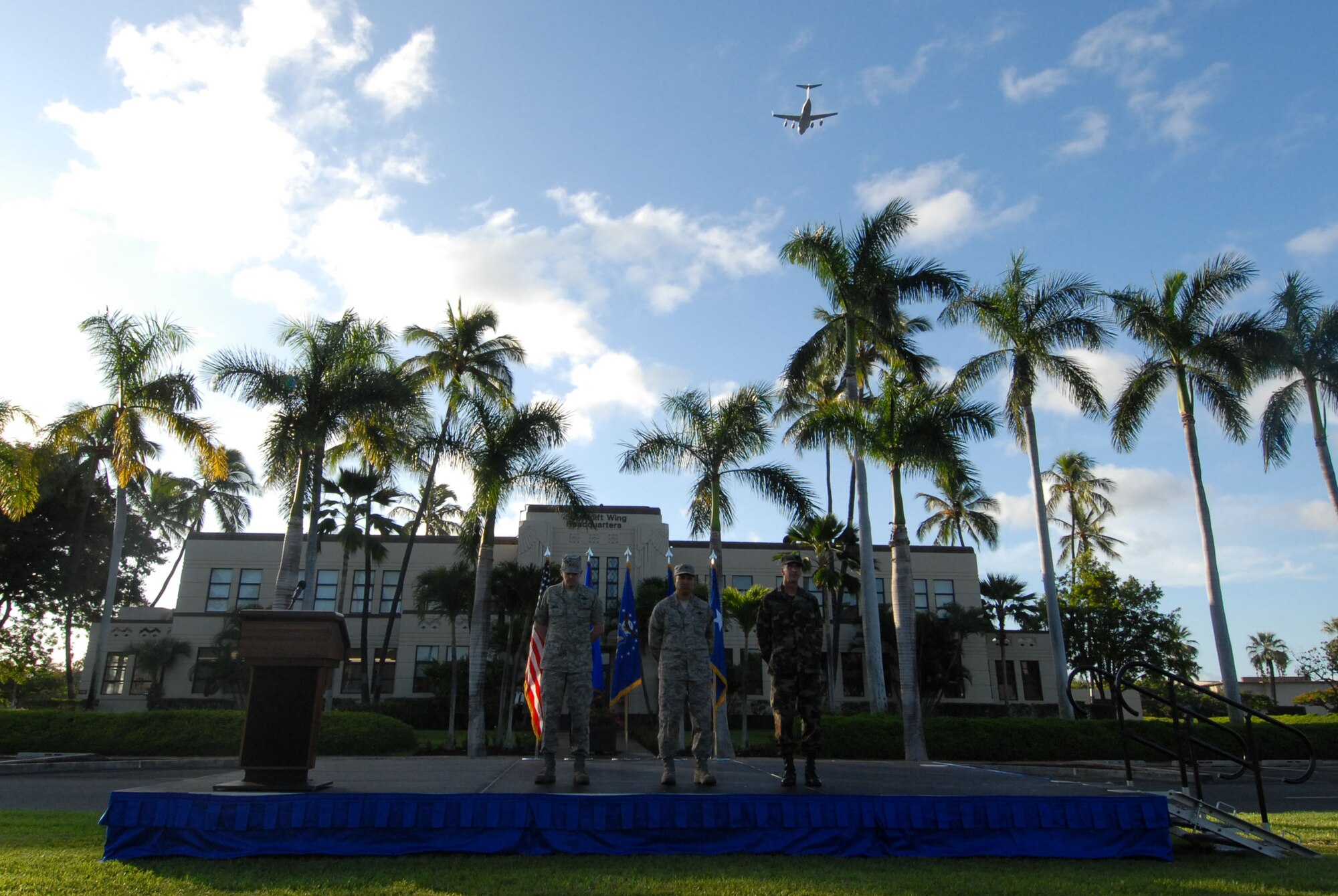 HICKAM AIR FORCE BASE, Hawaii -- Major Gen. Jan-Marc Jouas, Headquarters Pacific Air Forces director of operations, plans, requirements and programs, Col. Giovanni Tuck, 15th Airlift Wing commander, and  Chaplain (Lt. Col.) Joseph Deichert, 15th AW, standby while a Hickam C-17 conducts a fly-over during the Sept. 11 Remembrance Ceremony here. Instead of the monthly Warrior Run morale event,  Hickam Airman paid tribute to those who lost their lives on 9/11 with a moment of silence in formation during the ceremony. The 15th Airlift Wing C-17 fly-over further honored those on the 8th anniversary. (U.S. Air Force photo/Staff Sgt. Mike Meares)