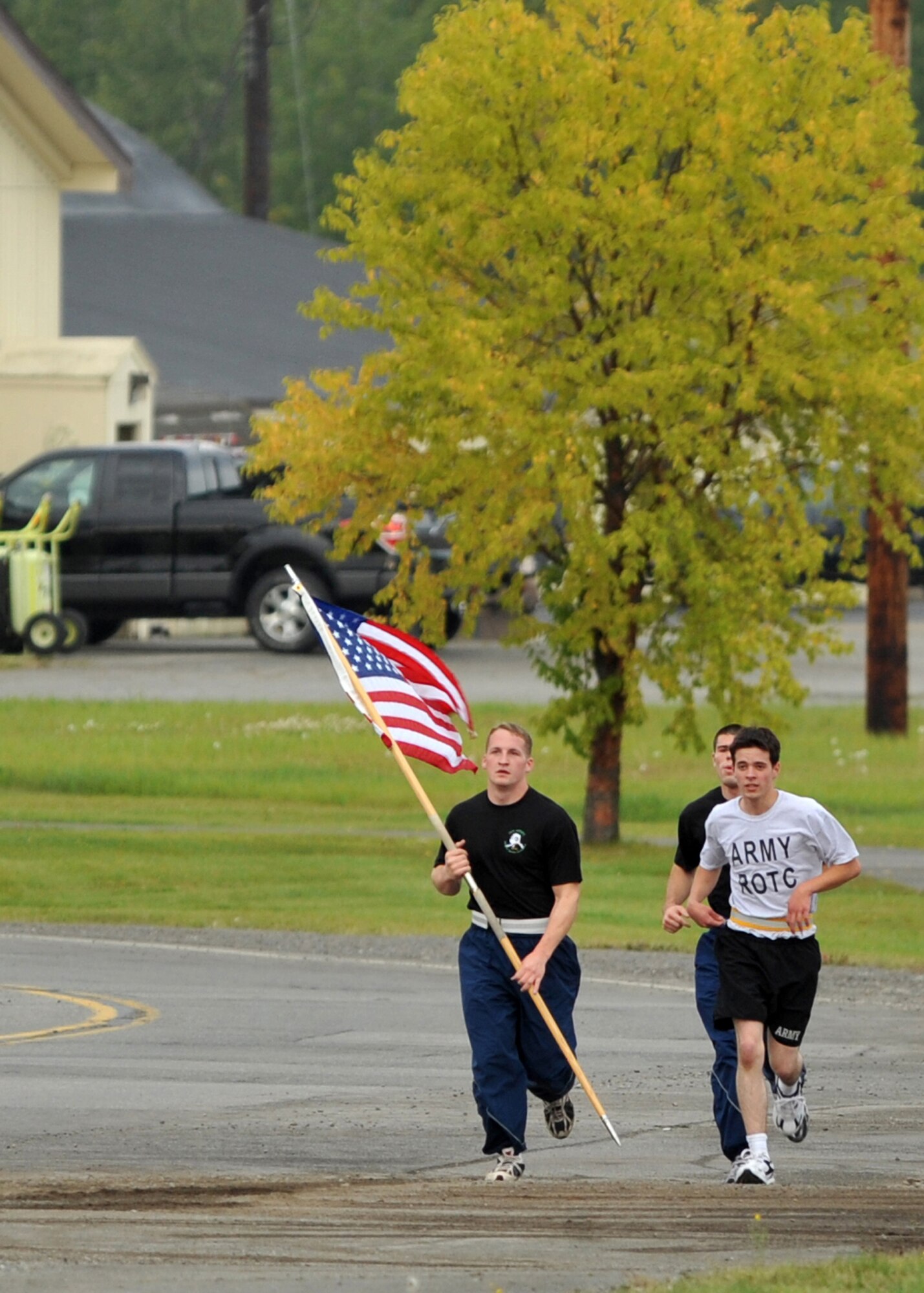 ELMENDORF AIR FORCE BASE, Alaska -- University of Alaska Anchorage Air Force ROTC cadets Nicholas George and Seth Grove, along with Army ROTC cadet Chris Carter, take turns carrying the American flag during a memorial run Sept. 11, 2009. The ROTC cadets ran around Elmendorf for 24 hours beginning at 8:46 a.m., the time the first of the World Trade Center twin towers was hit in 2001. The cadets were relieved by other runners every half hour during the 24-hour period. (U.S. Air Force photo/Senior Airman Laura Turner)