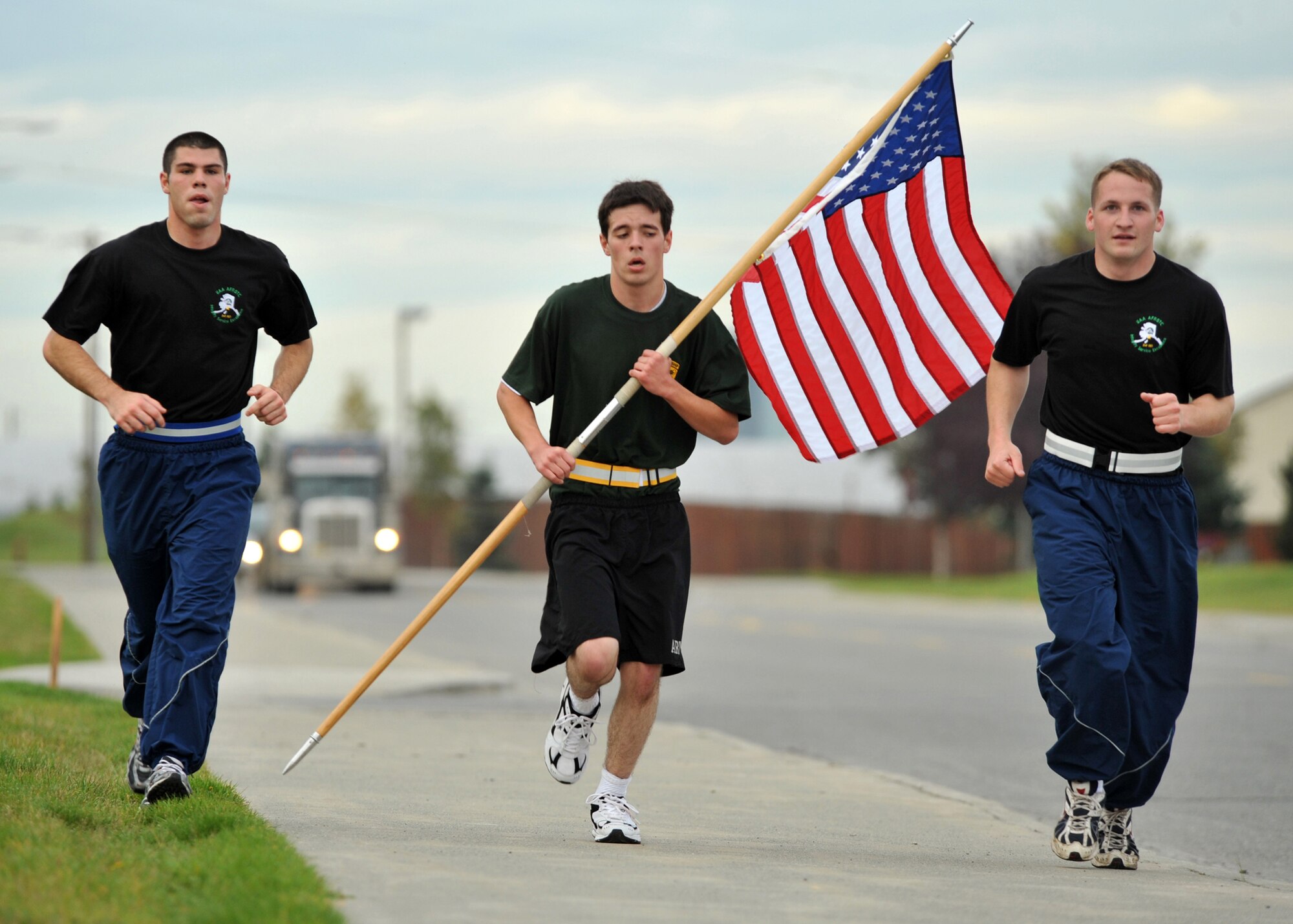 ELMENDORF AIR FORCE BASE, Alaska -- University of Alaska Anchorage Army ROTC cadet Chris Carter takes his turn carrying the American flag with Air Force ROTC students during a memorial run Sept. 11, 2009. The ROTC cadets ran around Elmendorf for 24 hours beginning at 8:46 a.m., the time the first of the World Trade Center twin towers was hit in 2001. The cadets were relieved by other runners every half hour during the 24-hour period. (U.S. Air Force photo/Senior Airman Laura Turner)
