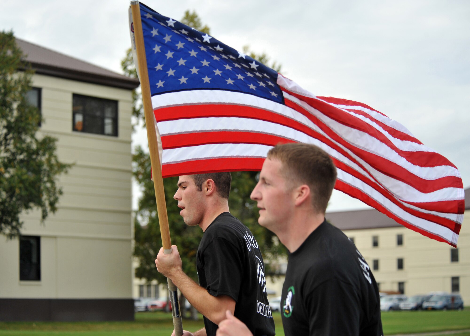 ELMENDORF AIR FORCE BASE, Alaska -- University of Alaska Anchorage Air Force ROTC cadets Nicholas George and Seth Grove take turns carrying the American flag during a memorial run Sept. 11, 2009. The ROTC cadets ran around Elmendorf for 24 hours beginning at 8:46 a.m., the time the first of the World Trade Center twin towers was hit in 2001. The cadets were relieved by other runners every half hour during the 24-hour period. (U.S. Air Force photo/Senior Airman Laura Turner)
