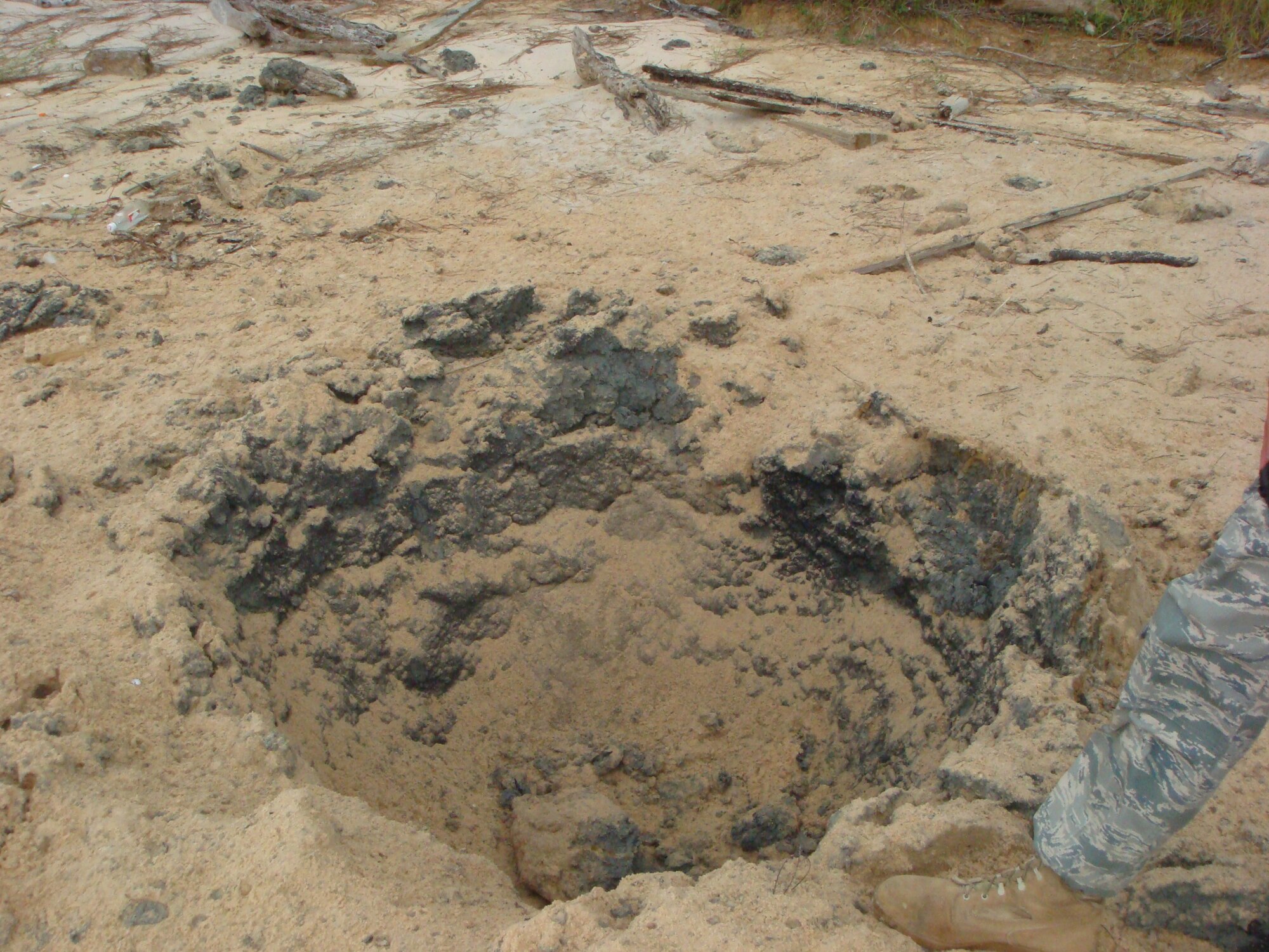 This crater is all that was left after explosive ordnance disposal technicians from Hurlburt Field destroyed a 21-inch-long canister during an off-base response in Dauphin Island, Ala. The item is a marine marker, which is basically the water version of a road flare.  (Courtesy photo)                               