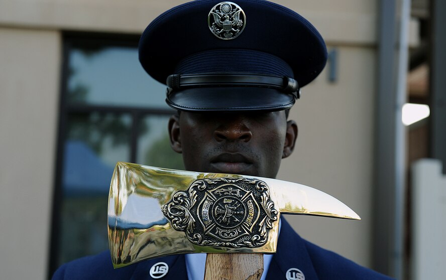 MOODY AIR FORCE BASE, Ga. -- Airman 1st Class Elvis Shaw, 23rd Civil Engineering Squadron firefighter, holds a fire axe in front of his face during the playing of the National Anthem during a 9/11 ceremony here Sept. 11. (U.S. Air Force photo by Airman 1st Class Joshua Green)