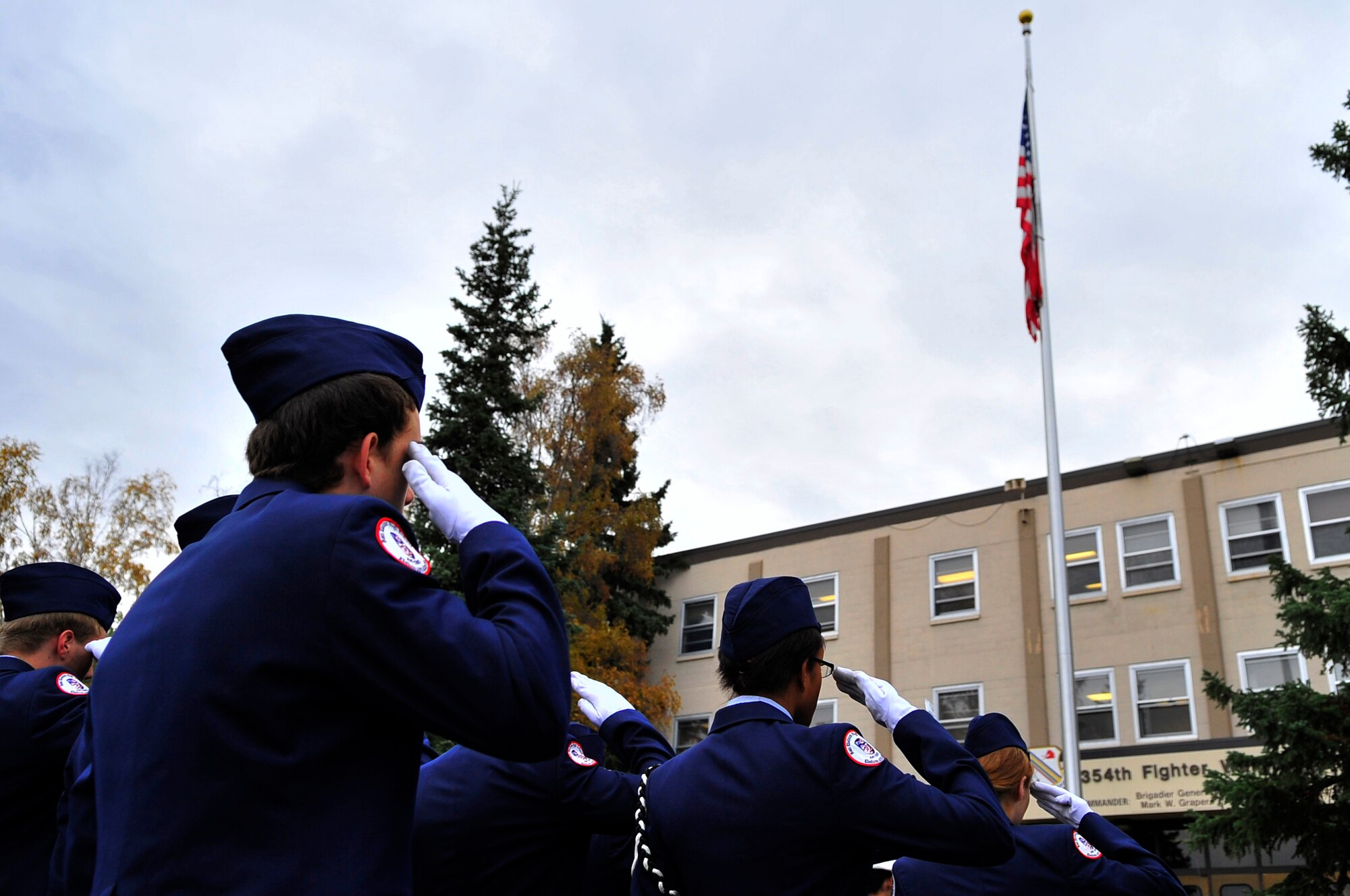 Cadets from Ben Eielson High School Air Force Junior Reserve Officers Training Corps salute as the flag is lowered to half staff during a ceremony in remembrance of the 9/11 attacks at the flag pole in front of Amber Hall Sept. 11, 2009, Eielson Air Force Base, Alaska. JROTC is a program designed to provide young men and women with an opportunity to learn and practice leadership skills. (U.S. Air Force photo/Staff Sgt. Christopher Boitz)