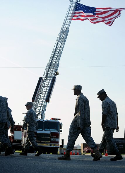 MOODY AIR FORCE BASE, Ga. -- The American flag blows in the wind while members from Moody walk past to find seats for the 9/11 ceremony here Sept. 11. Every year Airmen gather around the world to reflect on the events that took place on that day. (U.S. Air Force photo by Airman 1st Class Joshua Green) 