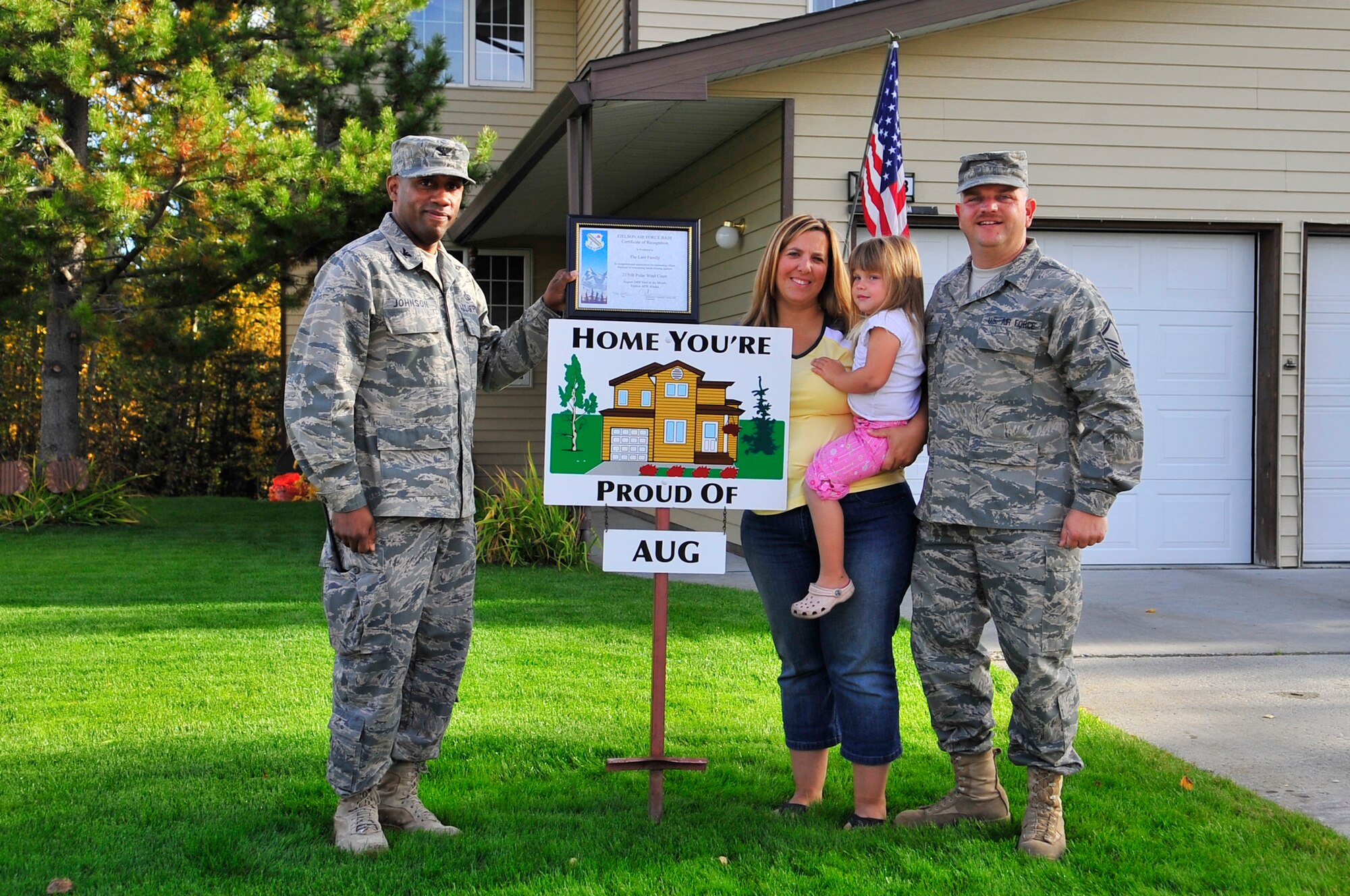 Master Sgt. Gary Lam and his family displays their Home You're Proud Of award with Col. Karlton Johnson Sept. 10, 2009, Eielson Air Force Base, Alaska. Each winner received gift cards from agencies on and off base. Sergeant Lam is assigned to the 354th Operations Support Squadron and Colonel Johnson is the 354th Mission Support Group commander. (U.S. Air Force photo/Staff Sgt. Christopher Boitz) 
